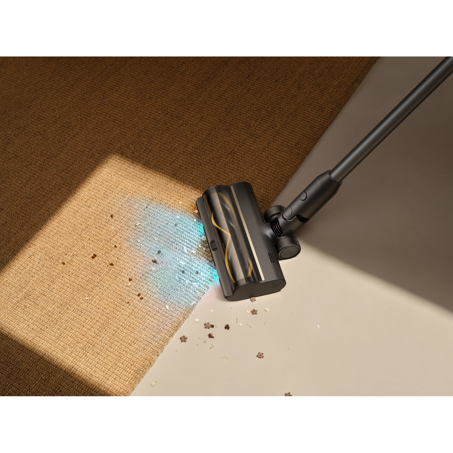 Een zwarte stofzuiger maakt een bruin tapijt schoon. Er ligt vuil op het tapijt en een lichtbeige vloer. De stofzuiger staat schuin.