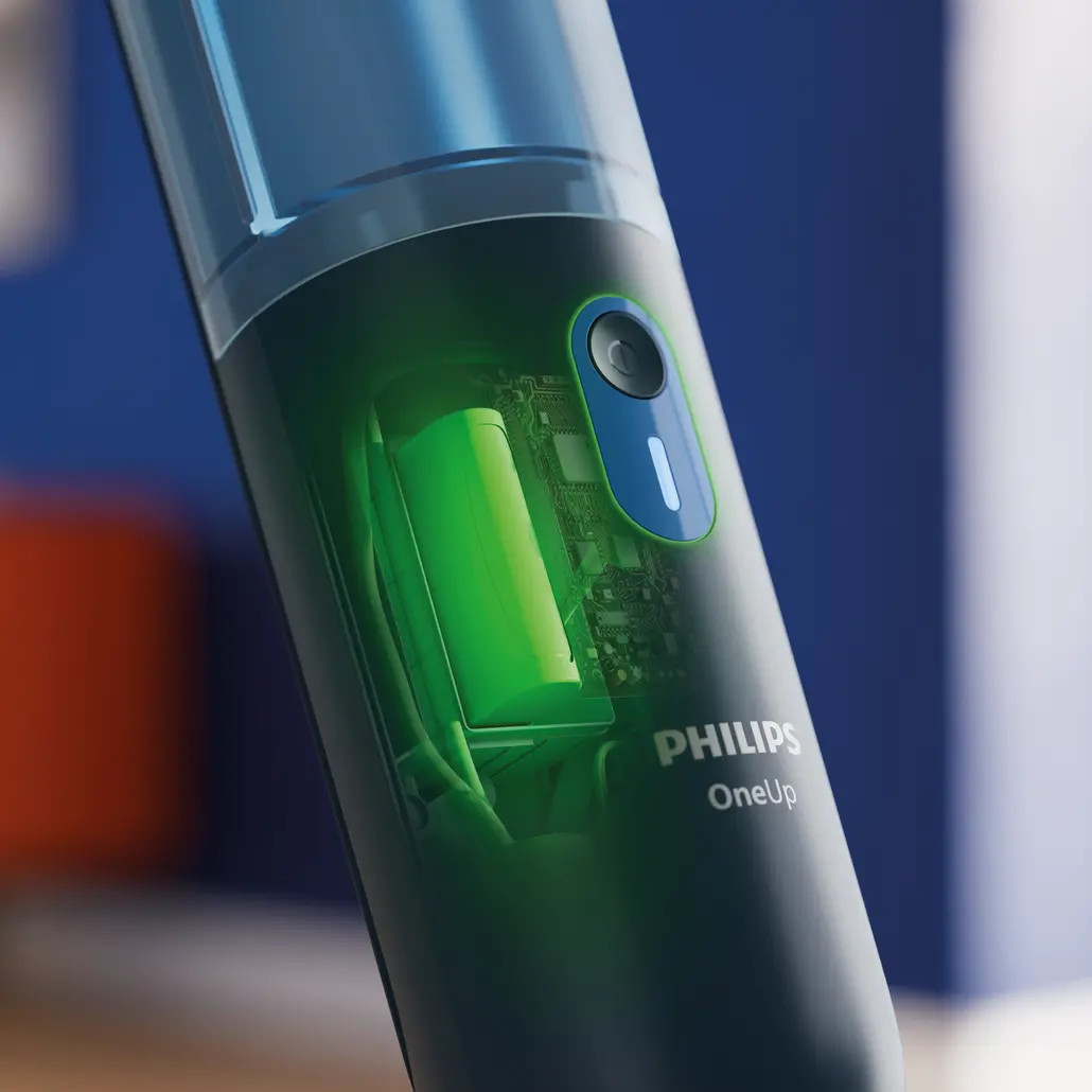 Zbliżenie elektrycznej szczoteczki do zębów Philips OneUp. Widoczne są elementy wewnętrzne, w tym zielony akumulator i płytka obwodu.