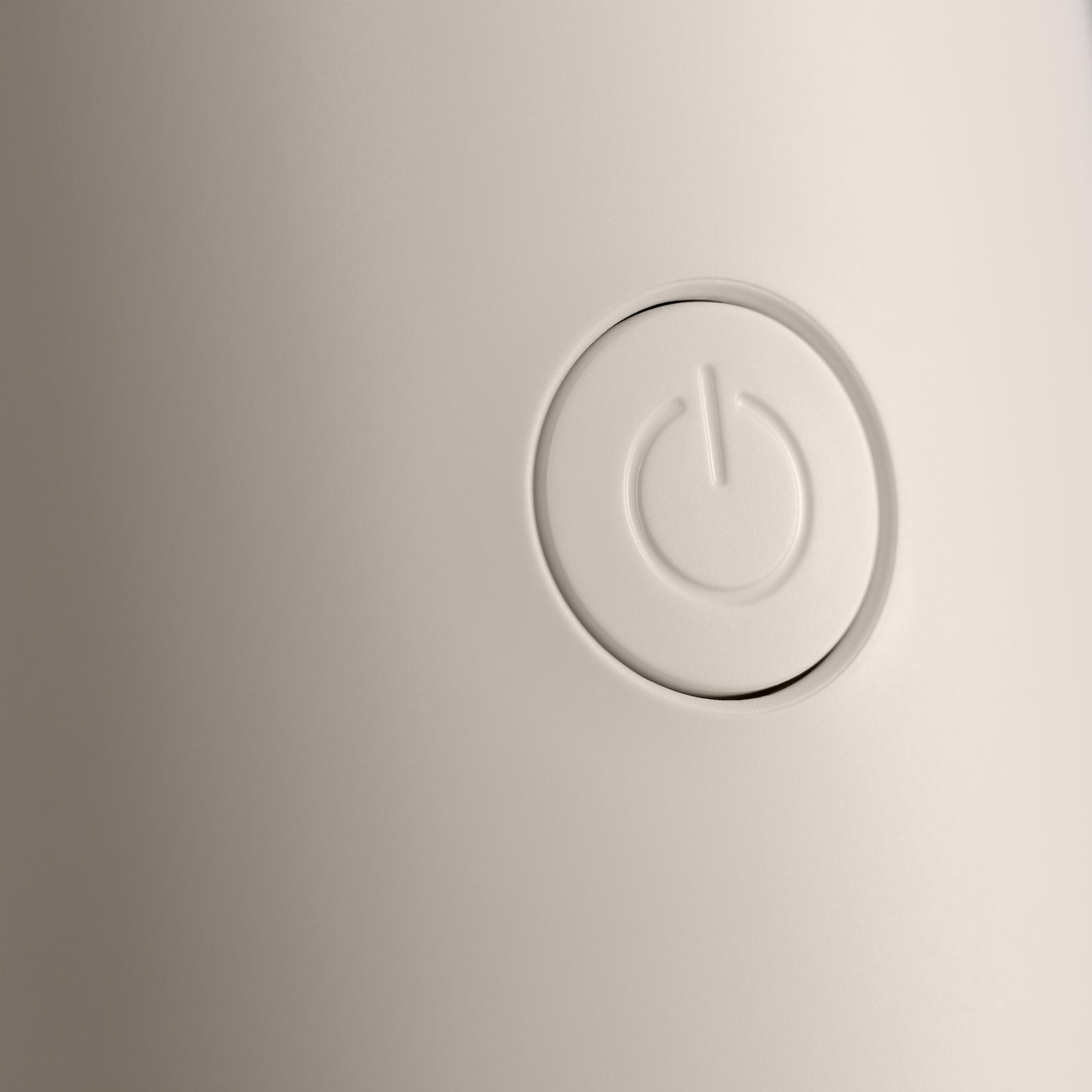 Nahaufnahme eines weißen Netzschalters auf einer weißen Oberfläche. Der Knopf ist ein Kreis mit einem Stromsymbol.