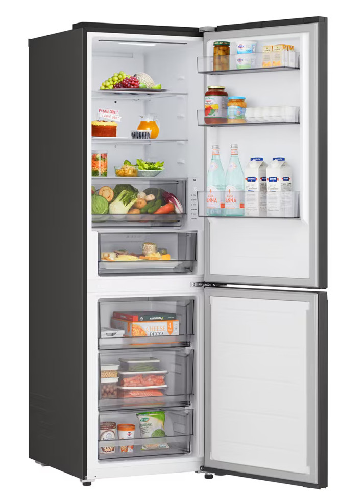 Otwarta lodówka wypełniona jedzeniem: owoce, warzywa, napoje, pizza, ciasto i inne. Czarny wygląd zewnętrzny, białe wnętrze, otwarte drzwi.