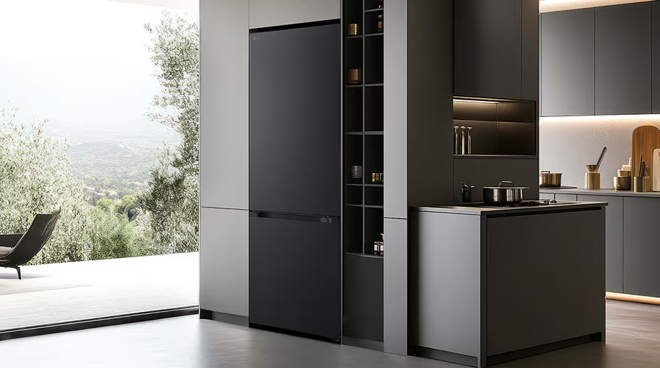 Nowoczesna kuchnia z czarną lodówką, ciemnymi szafkami i wyspą. Widok na naturę przez duże okno.