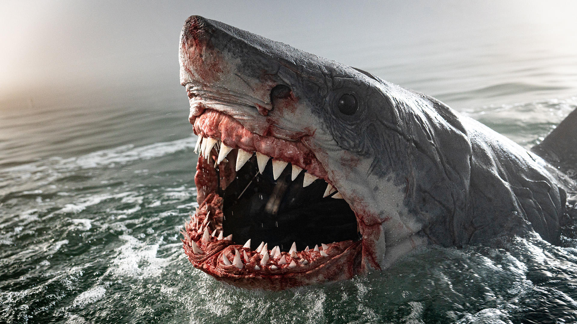 Ein großer Weißer Hai mit offenem, blutigem Maul taucht aus dem Wasser auf. Scharfe Zähne sind sichtbar, und das Wasser ist unruhig.