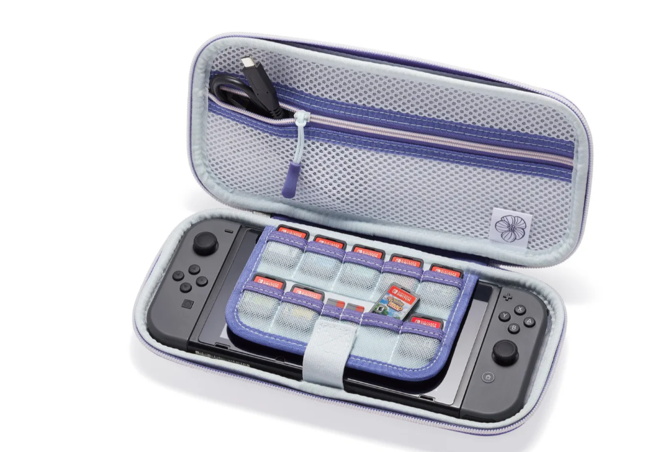 Eine Switch-Konsole in einem lila Etui, geöffnet, um die Konsole, Spielkassetten und ein Ladekabel zu zeigen.