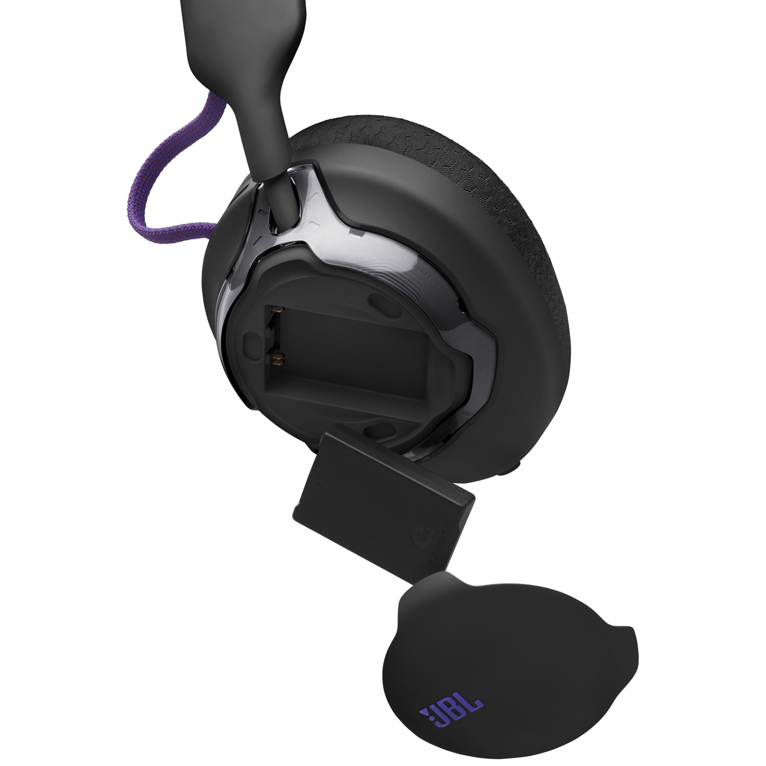 Un casque JBL noir avec des accents violets est montré. Le compartiment de la batterie est ouvert, révélant une pile.