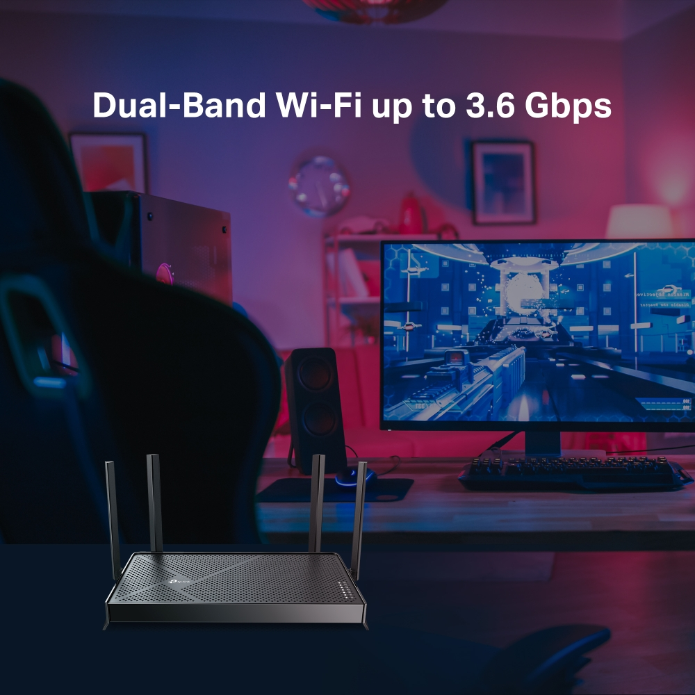 Un routeur Wi-Fi bi-bande avec antennes est posé sur un bureau, avec un moniteur et une configuration de jeu en arrière-plan.