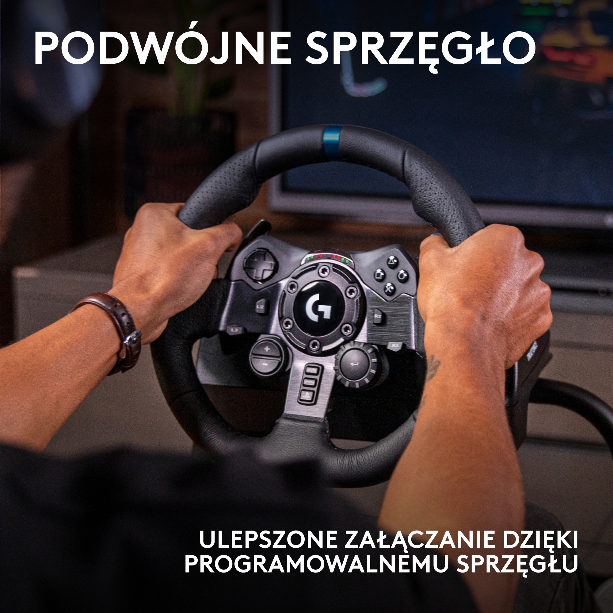 Dłonie trzymają czarną kierownicę wyścigową. Kierownica ma przyciski i logo. W tle widać ekran.
