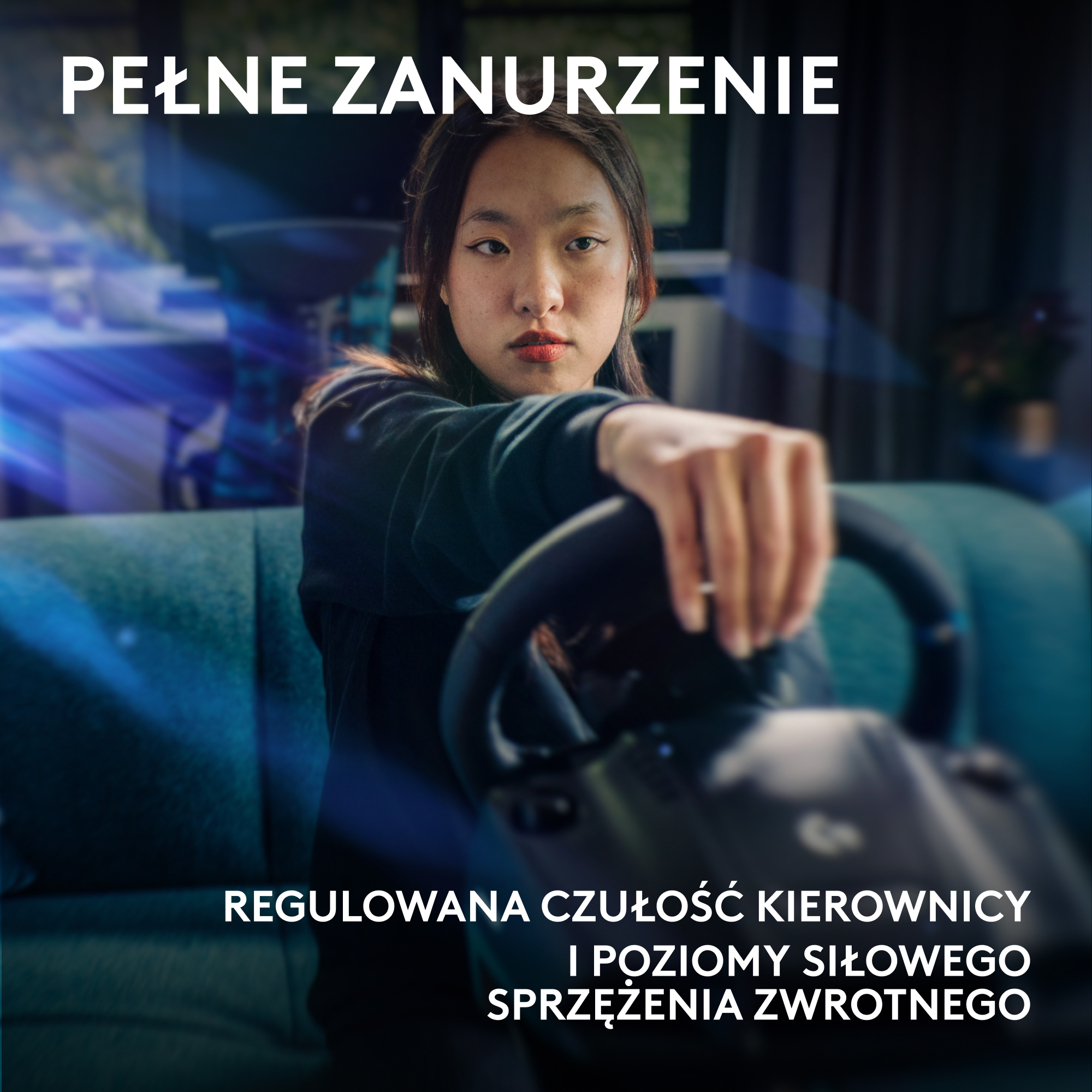 Młoda kobieta trzyma kierownicę przed niebieską kanapą. Tekst: 'PEŁNE ZANURZENIE', 'REGULOWANA CZUŁOŚĆ KIEROWNICY'.