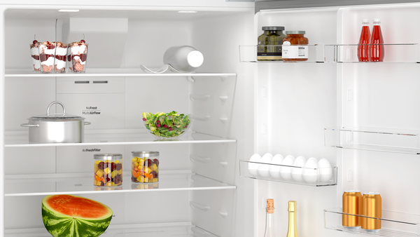 Yiyecek dolu buzdolabı içi. Tatlılar, salata, kavanozlar, karpuz, yumurta, içecekler ve bir tencere içerir.