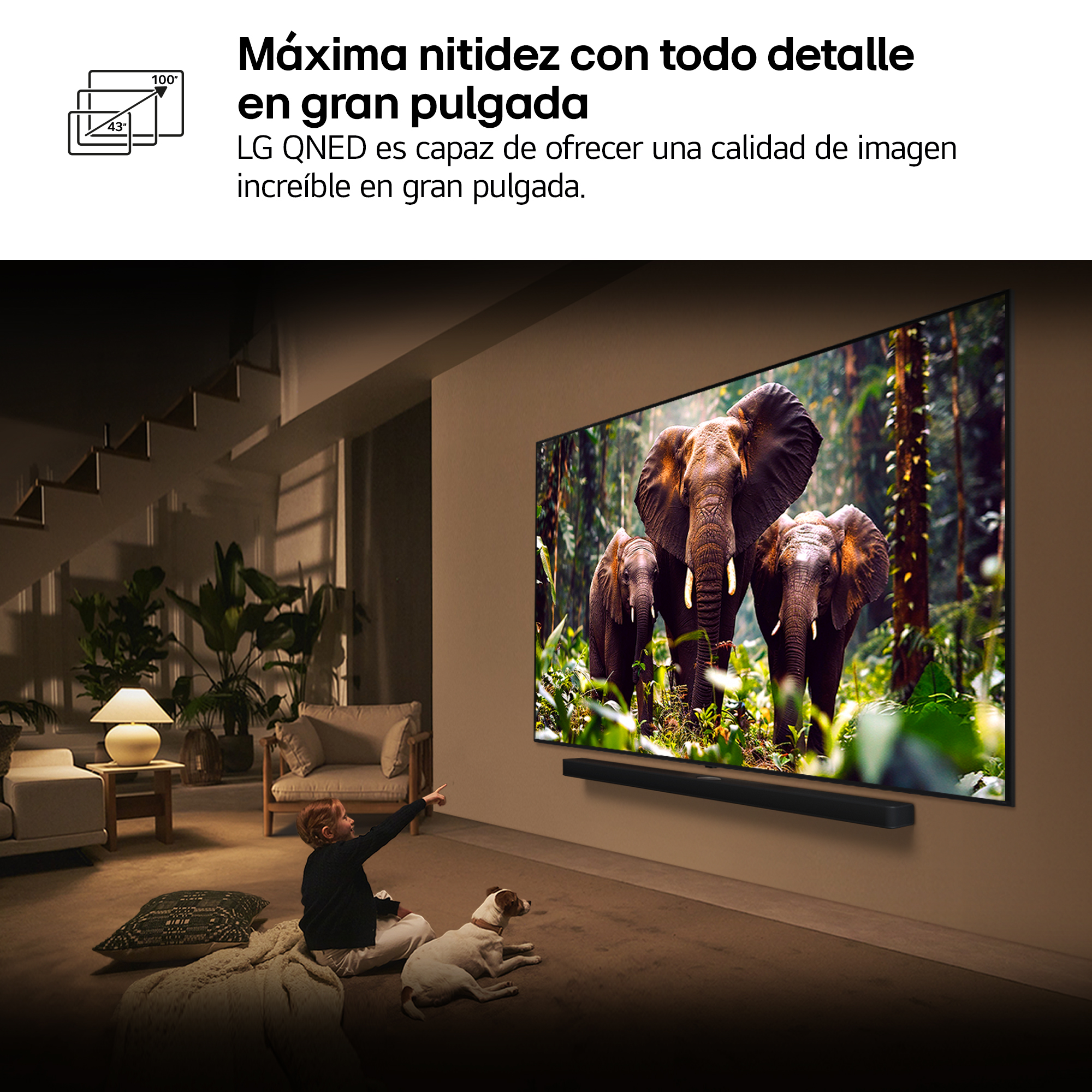 Un niño señala un televisor que muestra elefantes. Un perro está cerca. La habitación tiene una lámpara, plantas y un sofá.