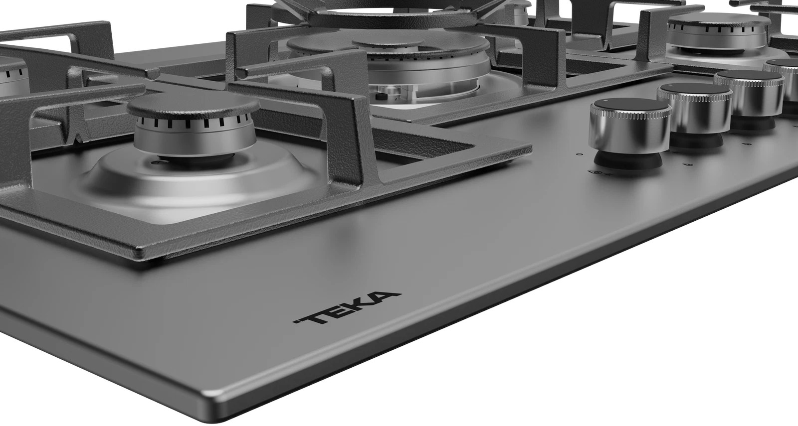 Zbliżenie kuchenki gazowej. Widoczne palniki, metalowe ruszty i pokrętła. Nadruk marki 'TEKA'.