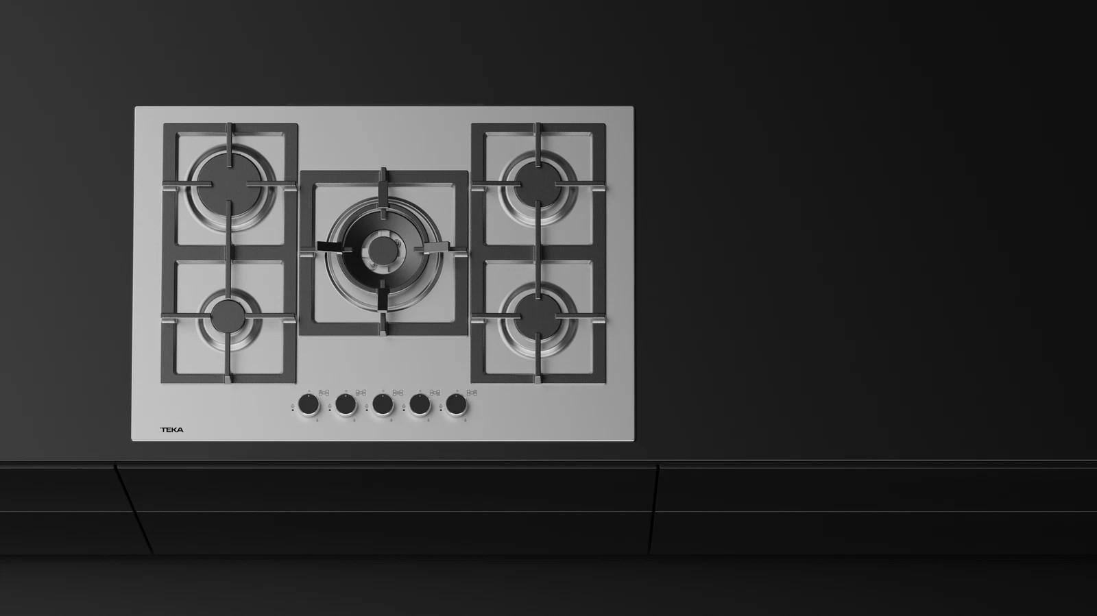Płyta gazowa ze stali nierdzewnej z pięcioma palnikami. Czarny blat i szafki. Widoczna marka TEKA.