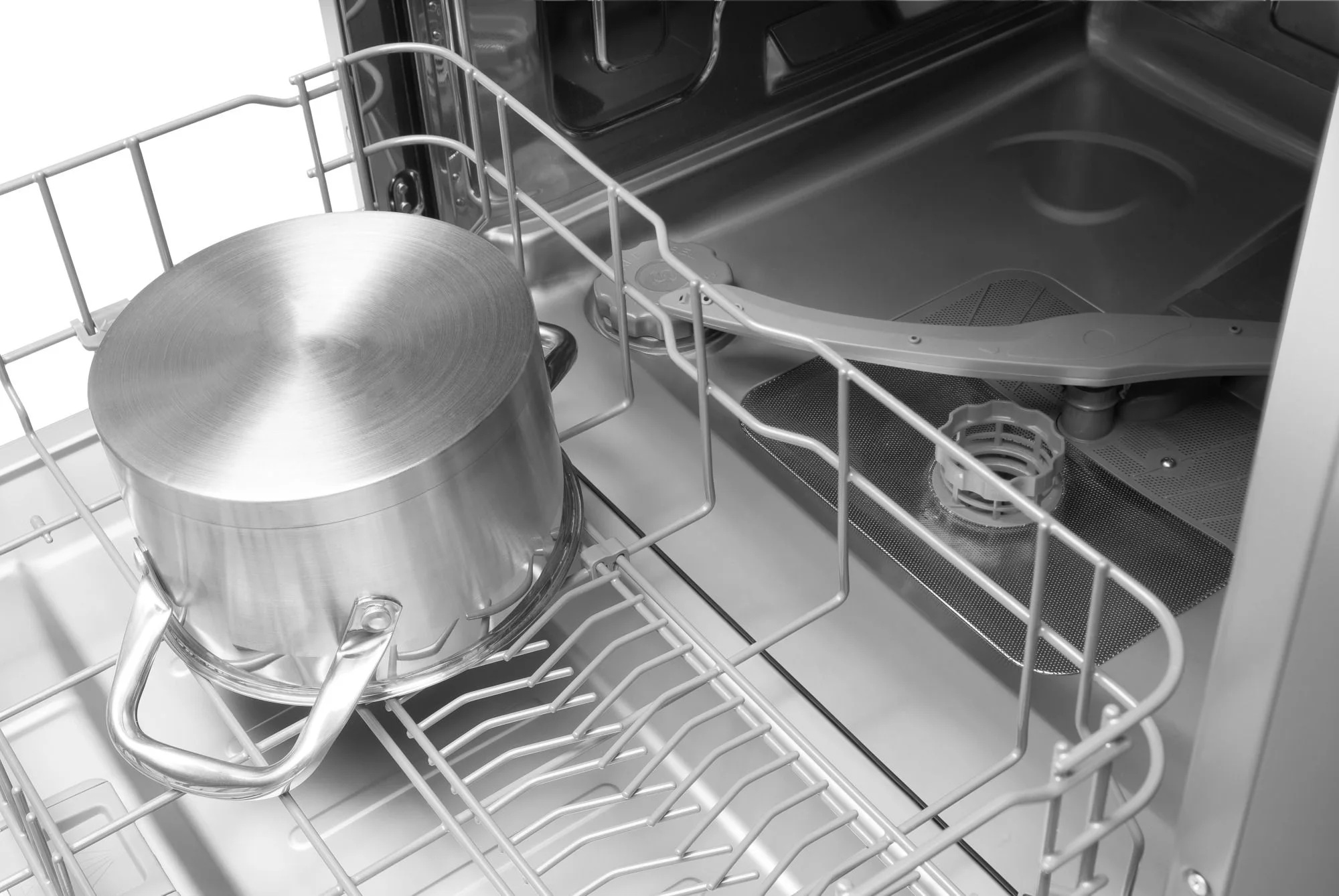 Garnek ze stali nierdzewnej w zmywarce. Wnętrze szare, z półką i ramieniem natryskowym.