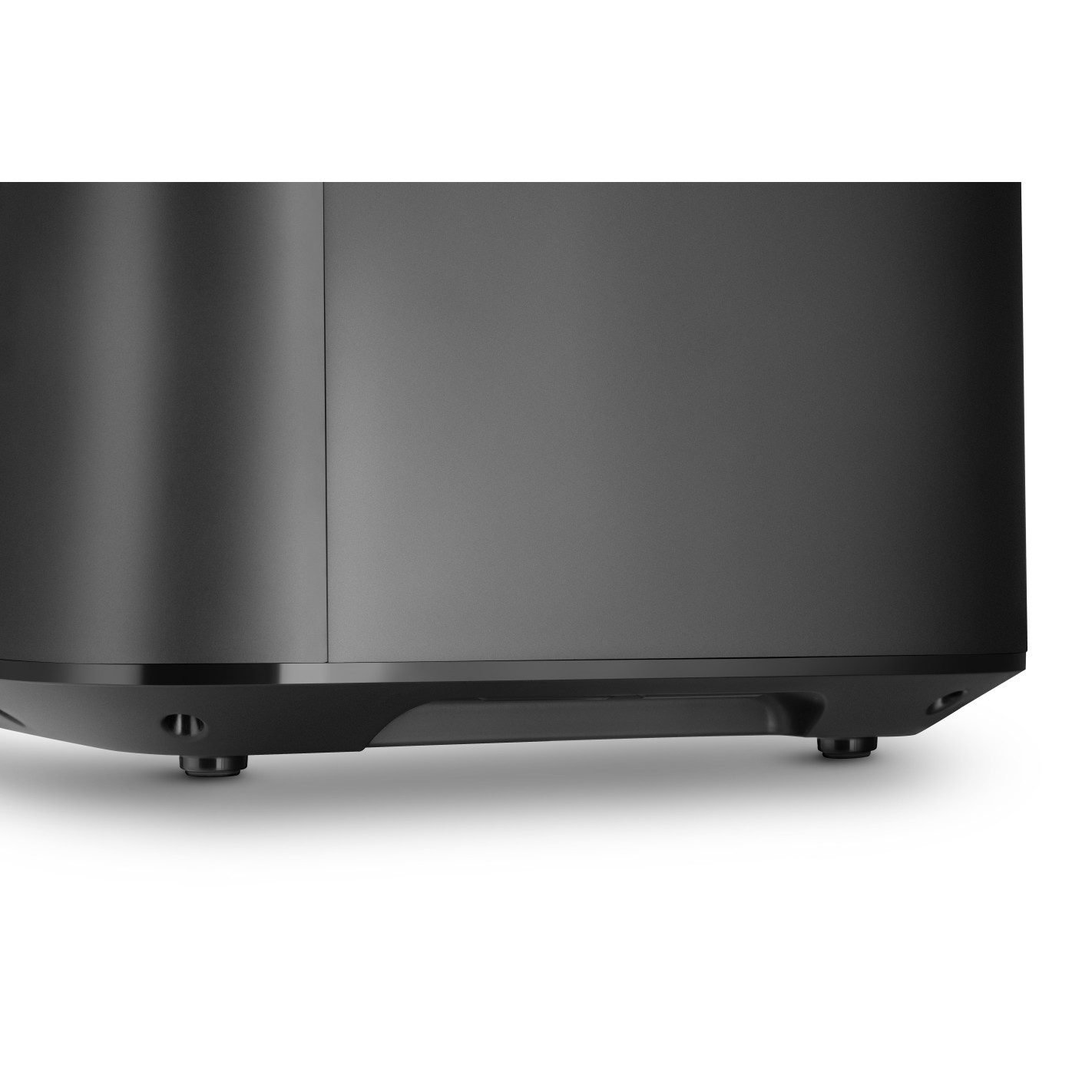 Zbliżenie czarnego głośnika. Ma zaokrąglony korpus z płaskim wierzchem. Głośnik spoczywa na małych, okrągłych nóżkach.