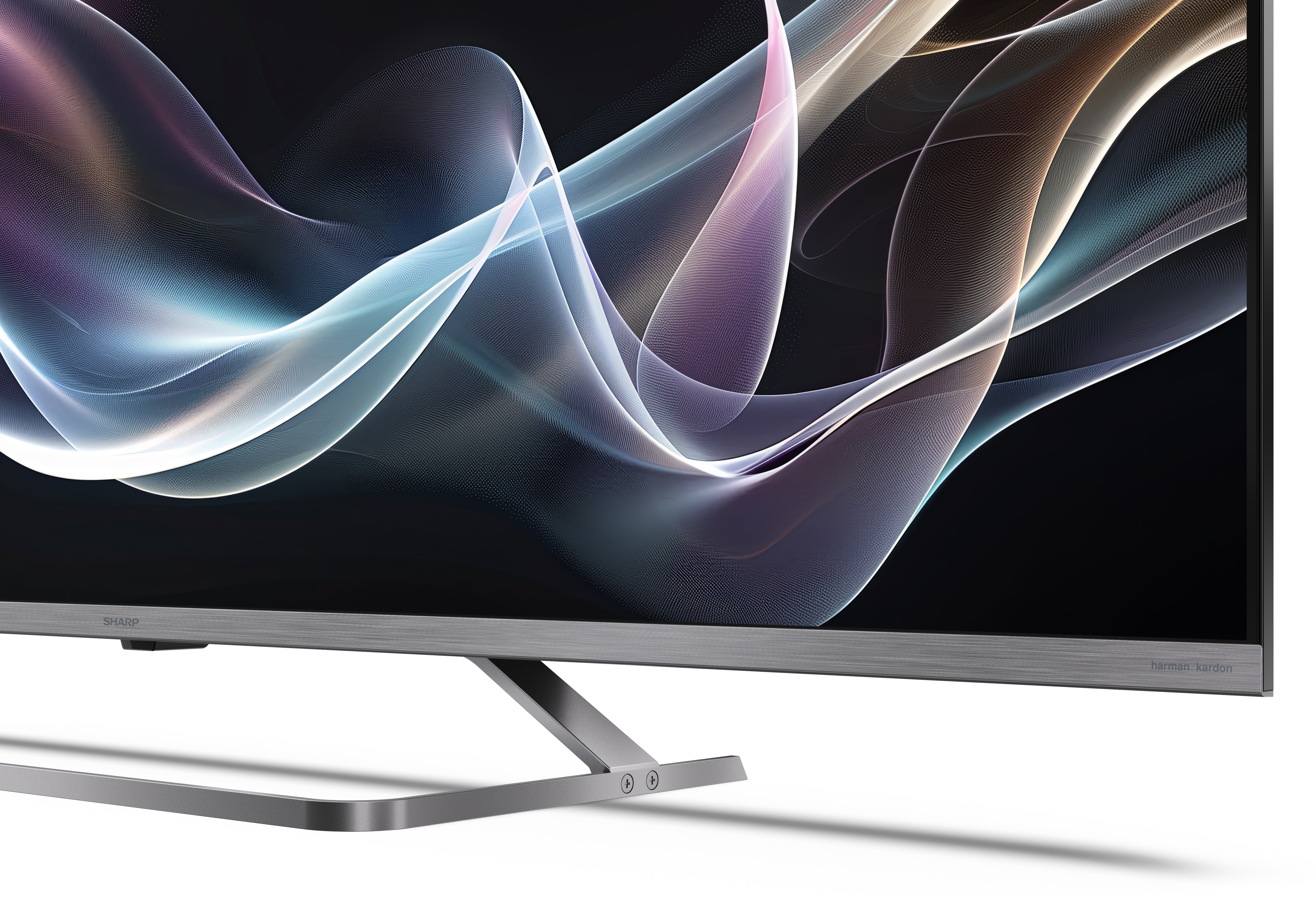 Telewizor Sharp wyświetla abstrakcyjny wzór wirujących, kolorowych linii na czarnym tle. Stojak jest metalowy.