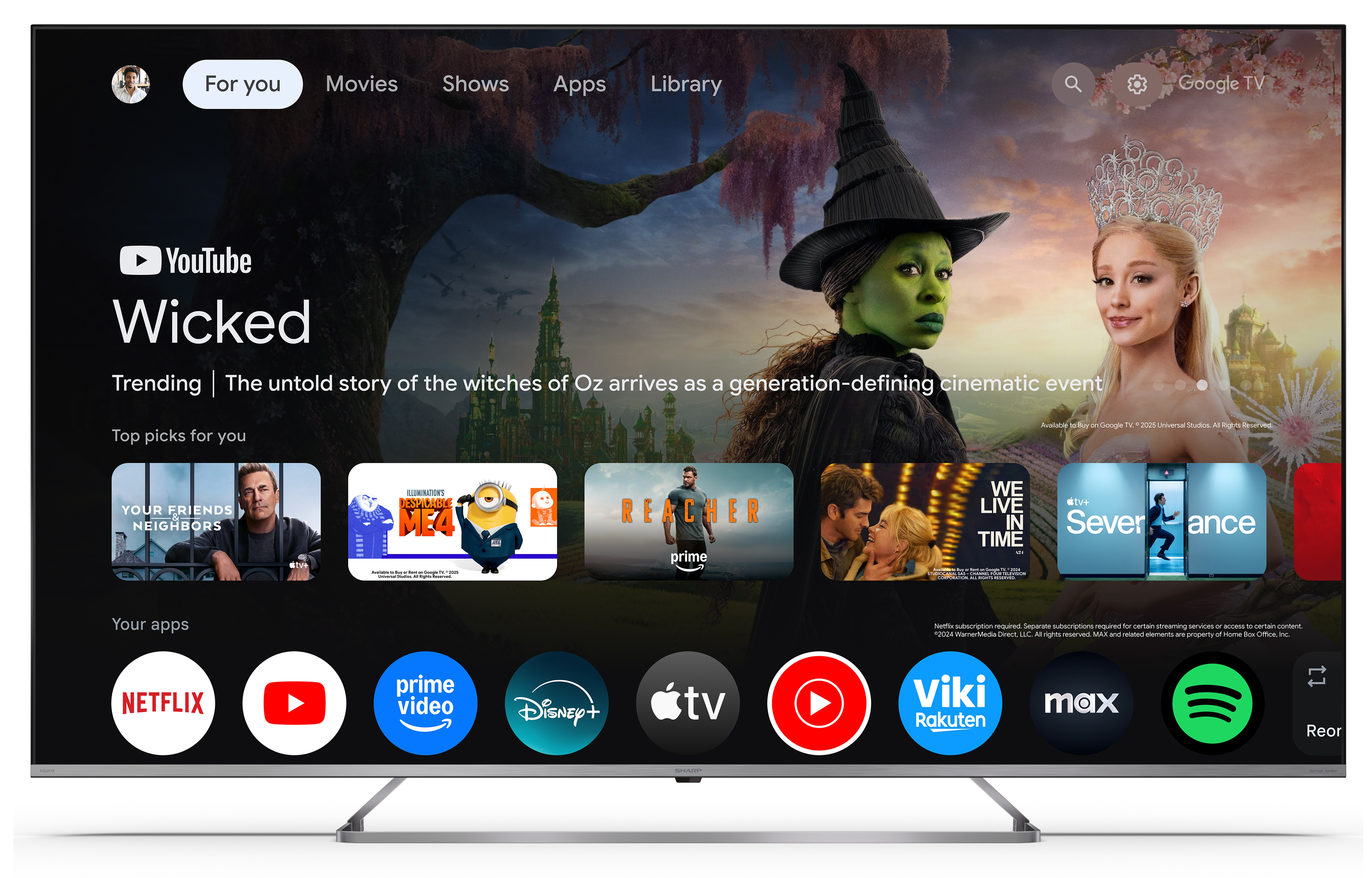 Ekran TV wyświetla promocję filmu 'Wicked'. Zawiera dwie aktorki, aplikacje takie jak Netflix, YouTube i inne streamingowe.