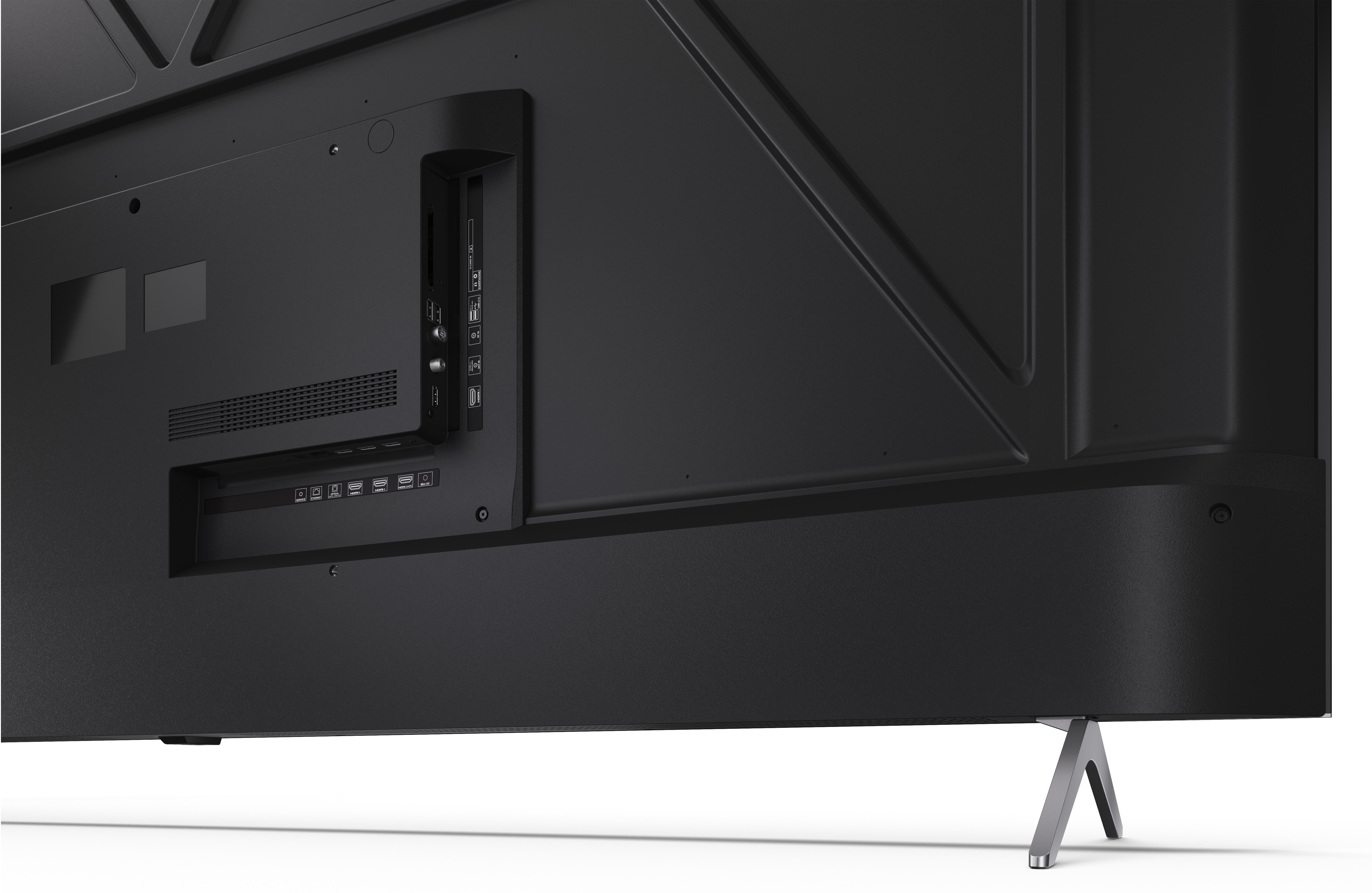 Tył czarnego telewizora z portami, otworami wentylacyjnymi i metalową podstawą. Biała powierzchnia na pierwszym planie.