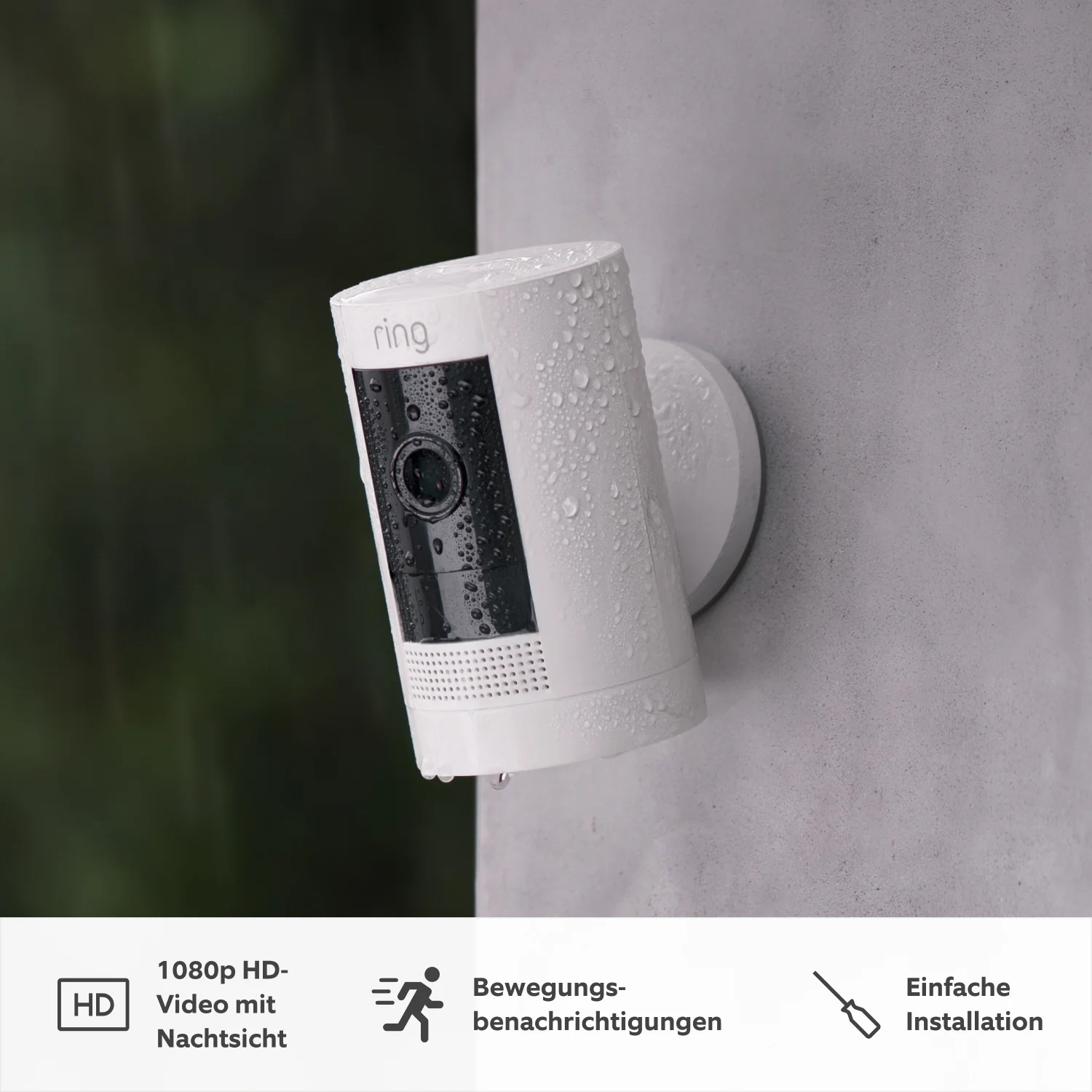 Eine weiße Ring-Überwachungskamera an der Wand, Wassertröpfchen sichtbar. Merkmale sind HD-Video, Bewegungsmeldungen und einfache Installation.