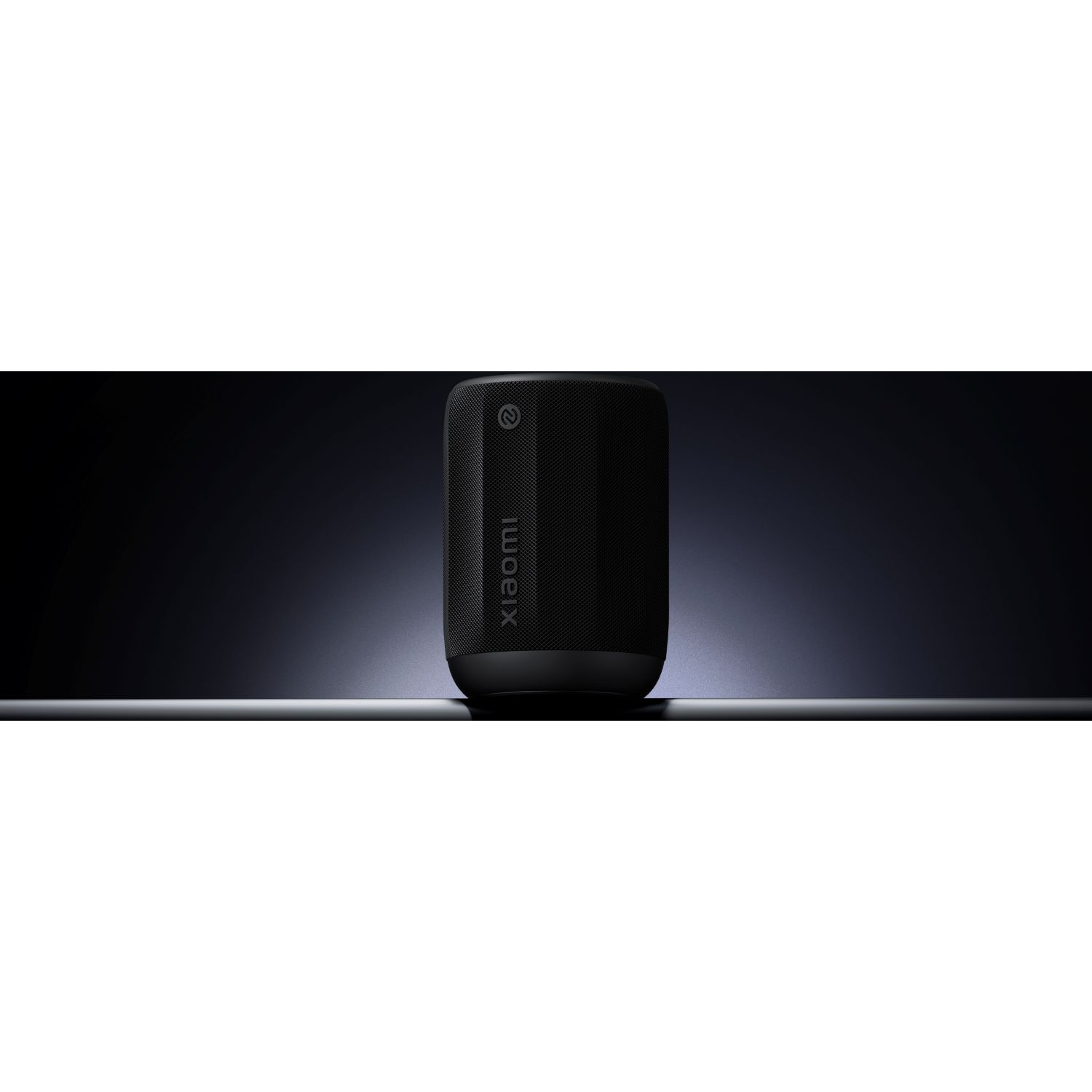 A black Xiaomi speaker stands centered against a dark gradient background, with the brand name visible.