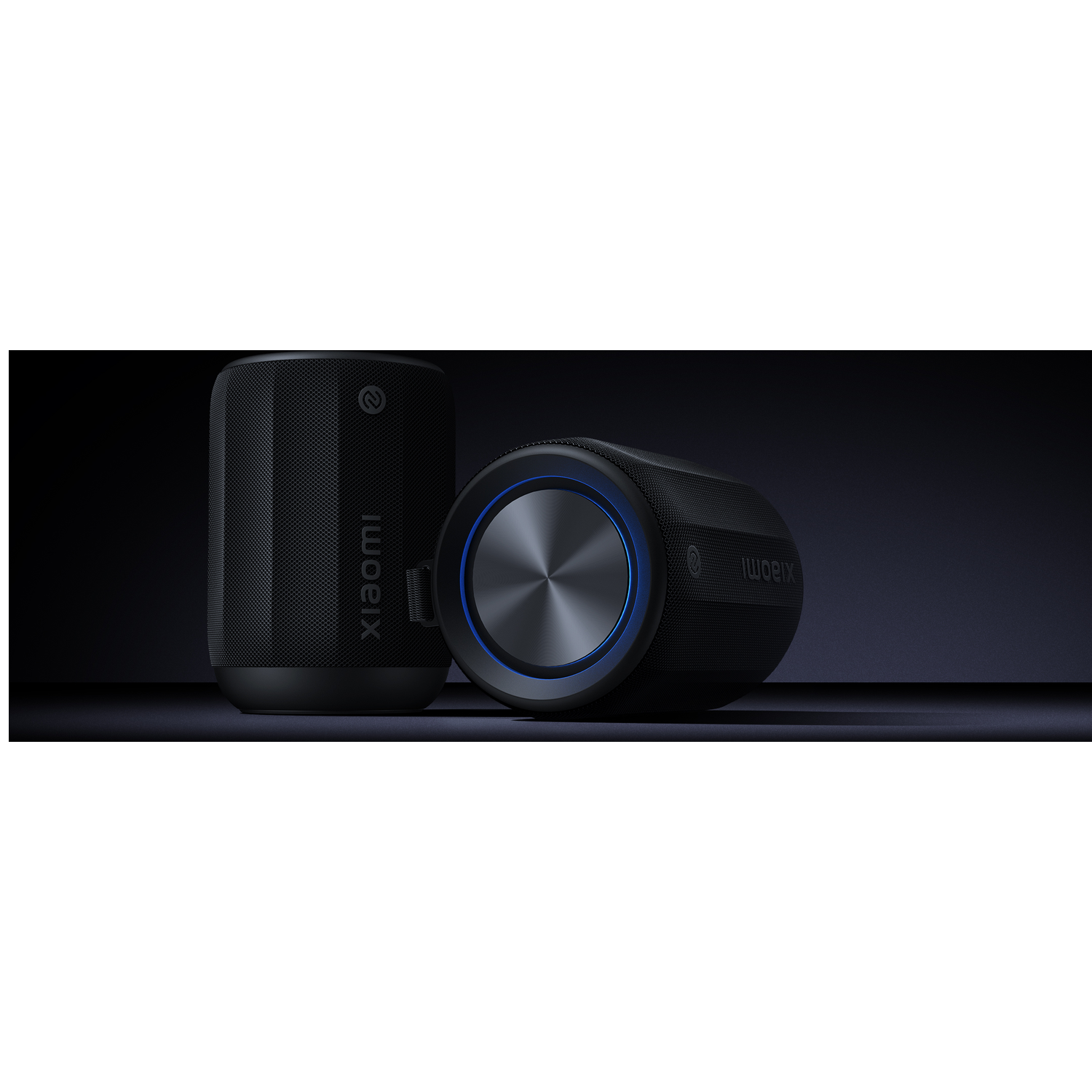 Two black cylindrical speakers. One upright, the other tilted. Both have a mesh texture and the word "Xiaomi".