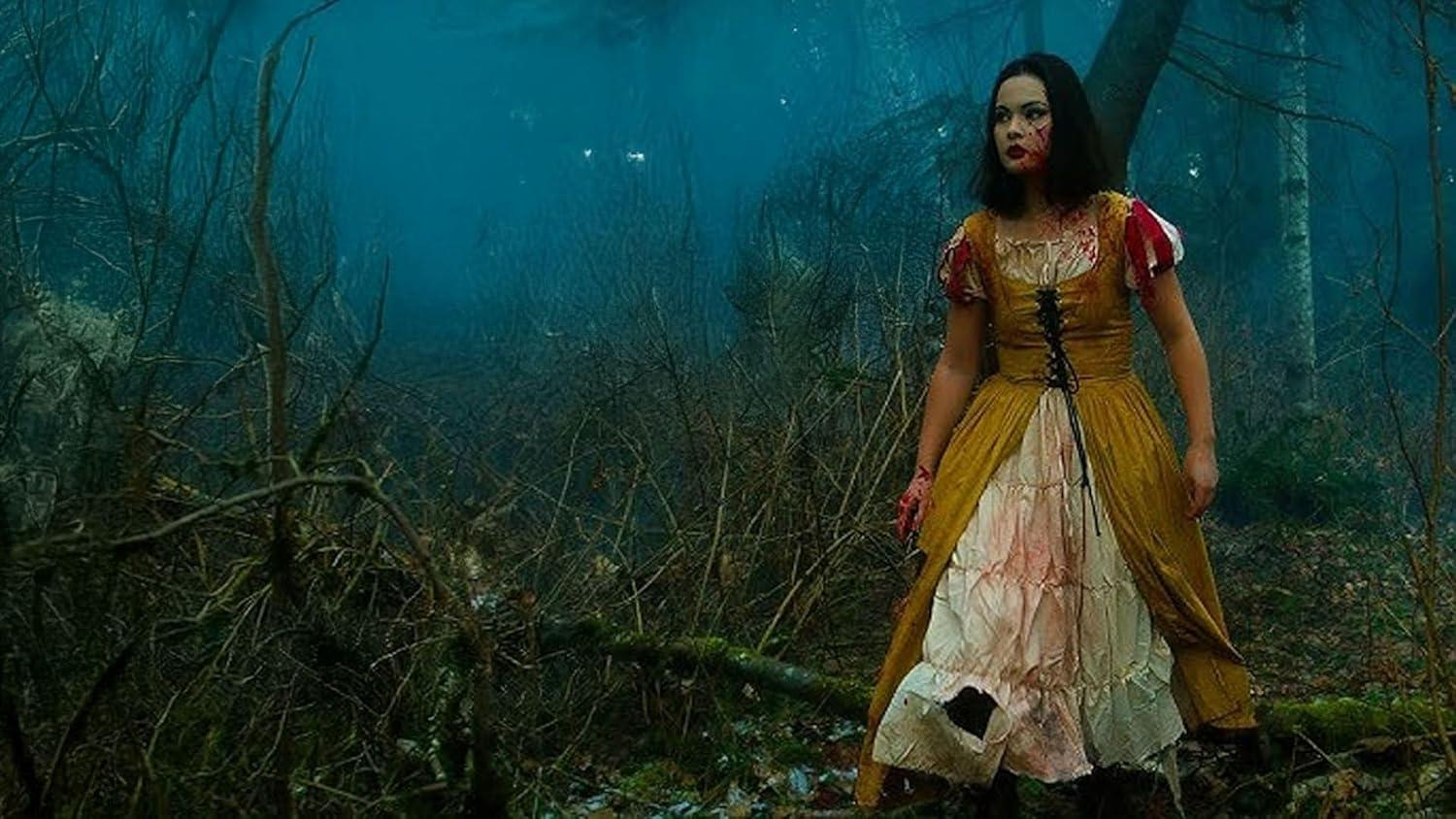 Eine Frau in einem blutbefleckten Kleid steht in einem dunklen Wald. Ihr Gesicht ist mit Blut verschmiert. Das Kleid ist gelb und weiß.