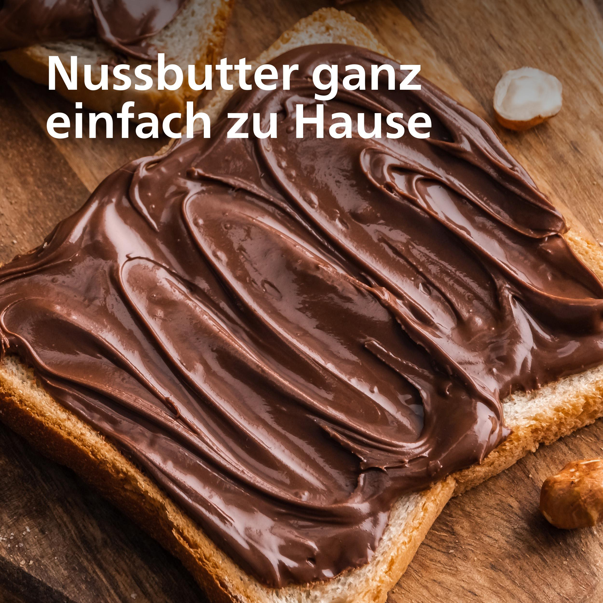 Toast mit Schokoladenaufstrich auf einem Holzbrett, mit Haselnüssen. Text: Nussbutter ganz einfach zu Hause.