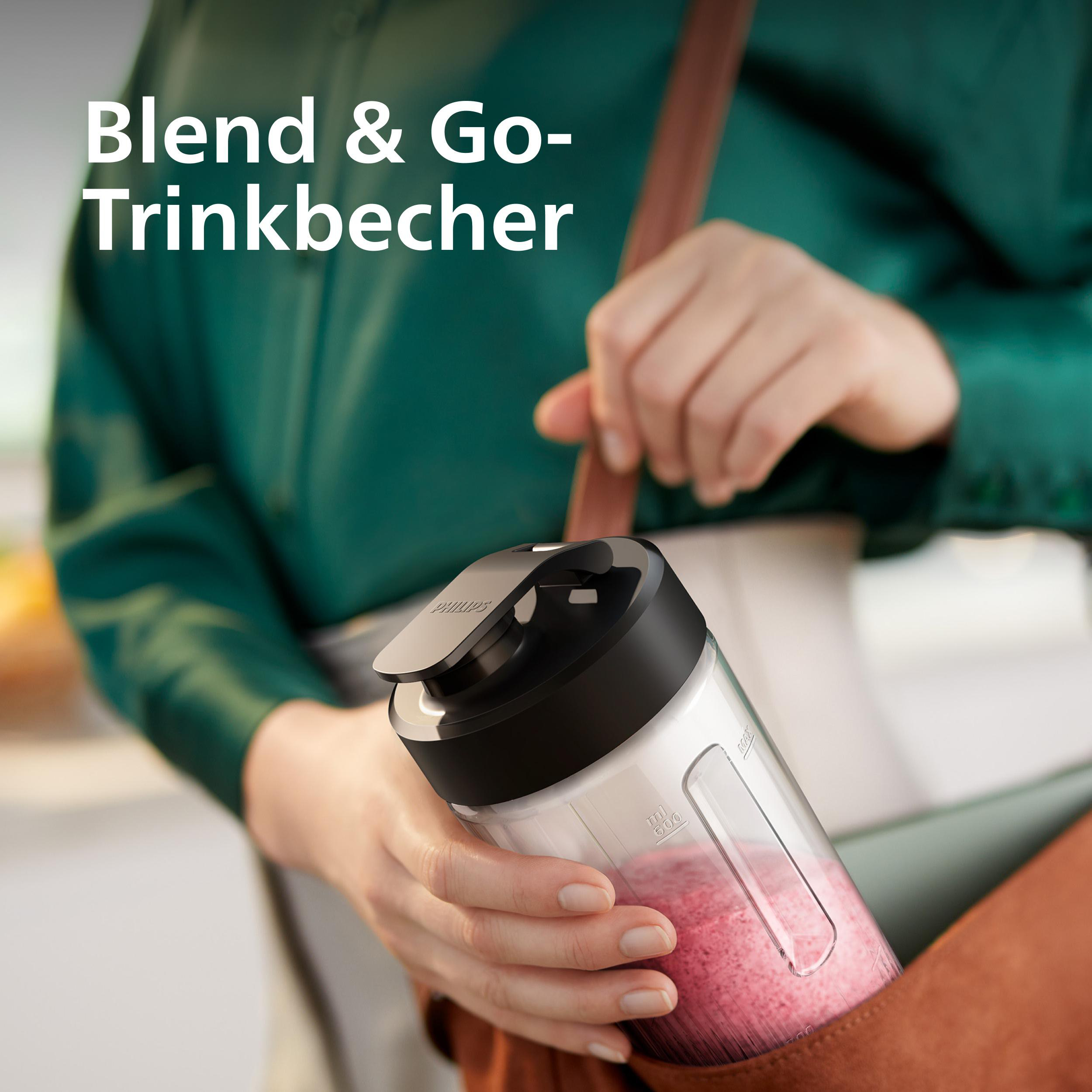 Eine Frau hält einen Philips Blend & Go-Trinkbecher mit rosa Inhalt. Der Hintergrund ist grün und eine braune Tasche.