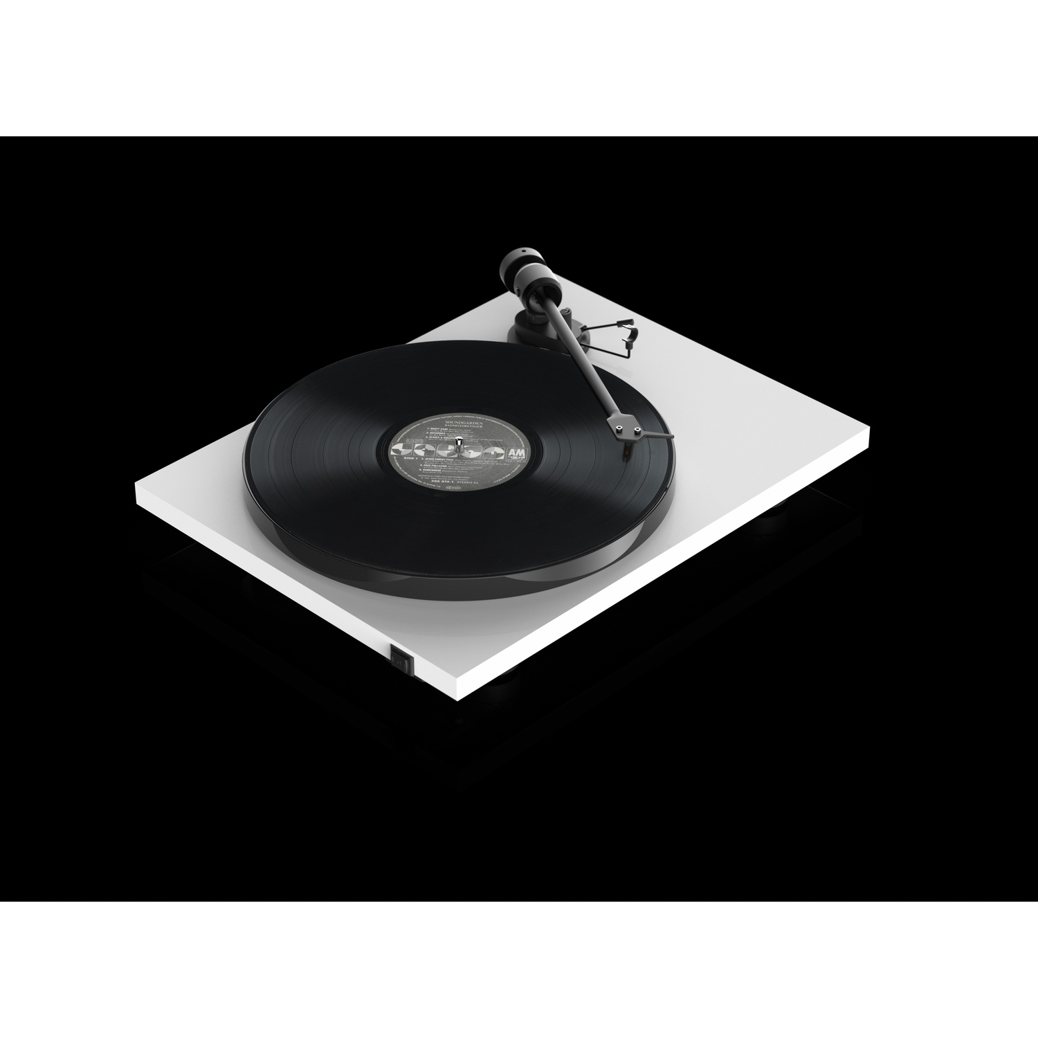 Un giradischi bianco con un disco nero in riproduzione. Il braccio è nero, lo sfondo è nero, design moderno.