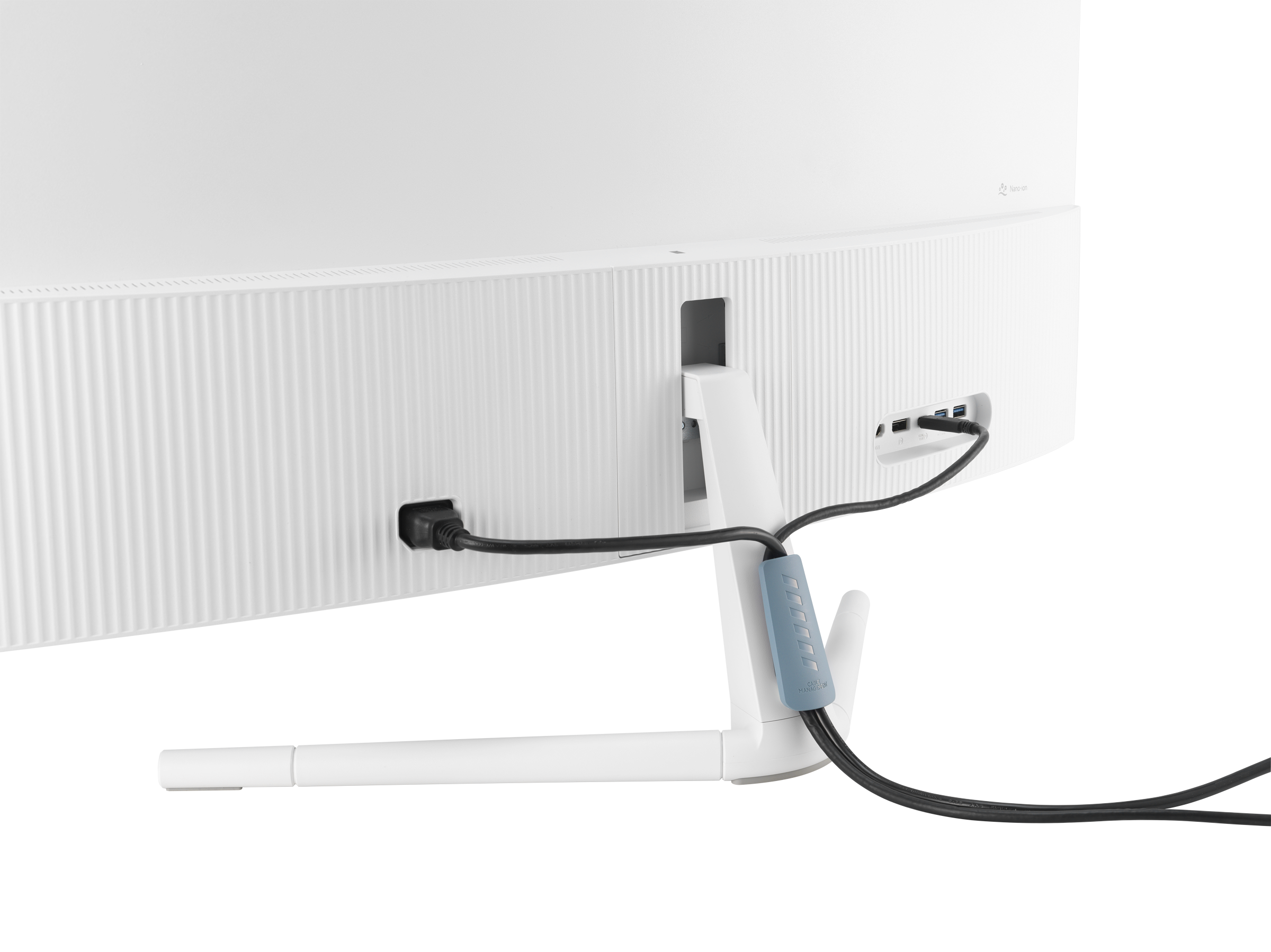 Fehér monitor hátulja, tápkábellel, fekete kábelekkel és egy kék kábelszervezővel. Fehér háttér.