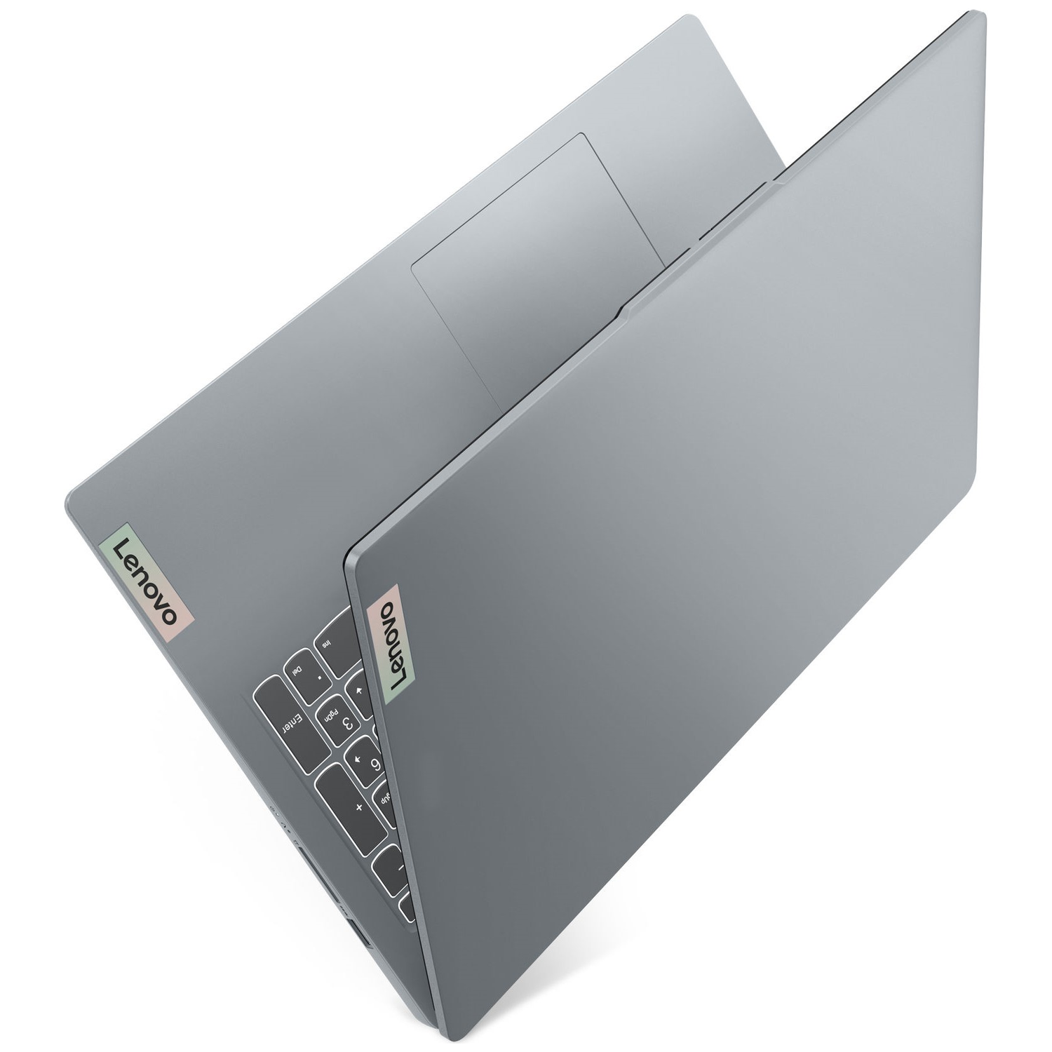 A gray Lenovo laptop is partially open. The keyboard and touchpad are visible, with a Lenovo sticker on the lid.