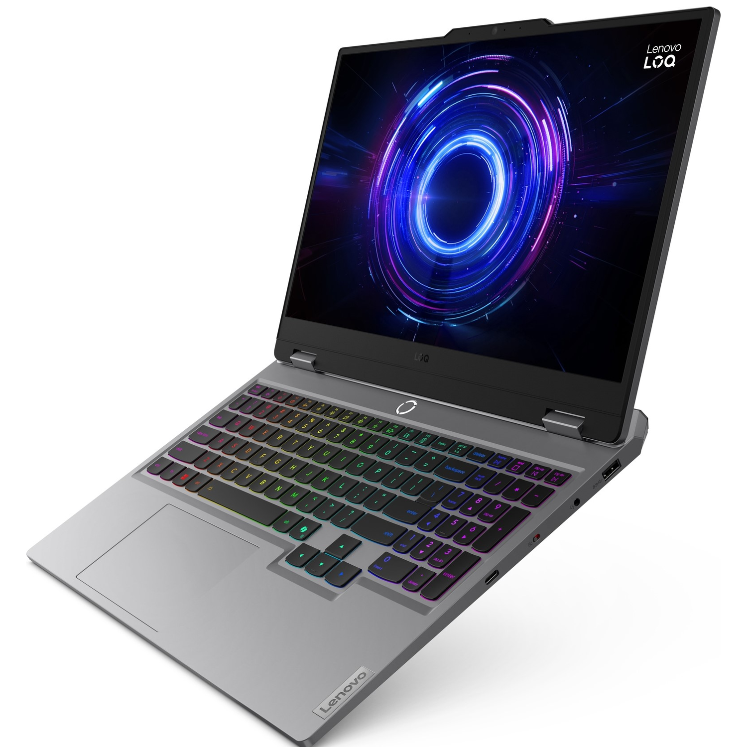 A silver Lenovo LOQ laptop is open, displaying a colorful screen. Keyboard keys are backlit with various colors. The Lenovo logo is visible.