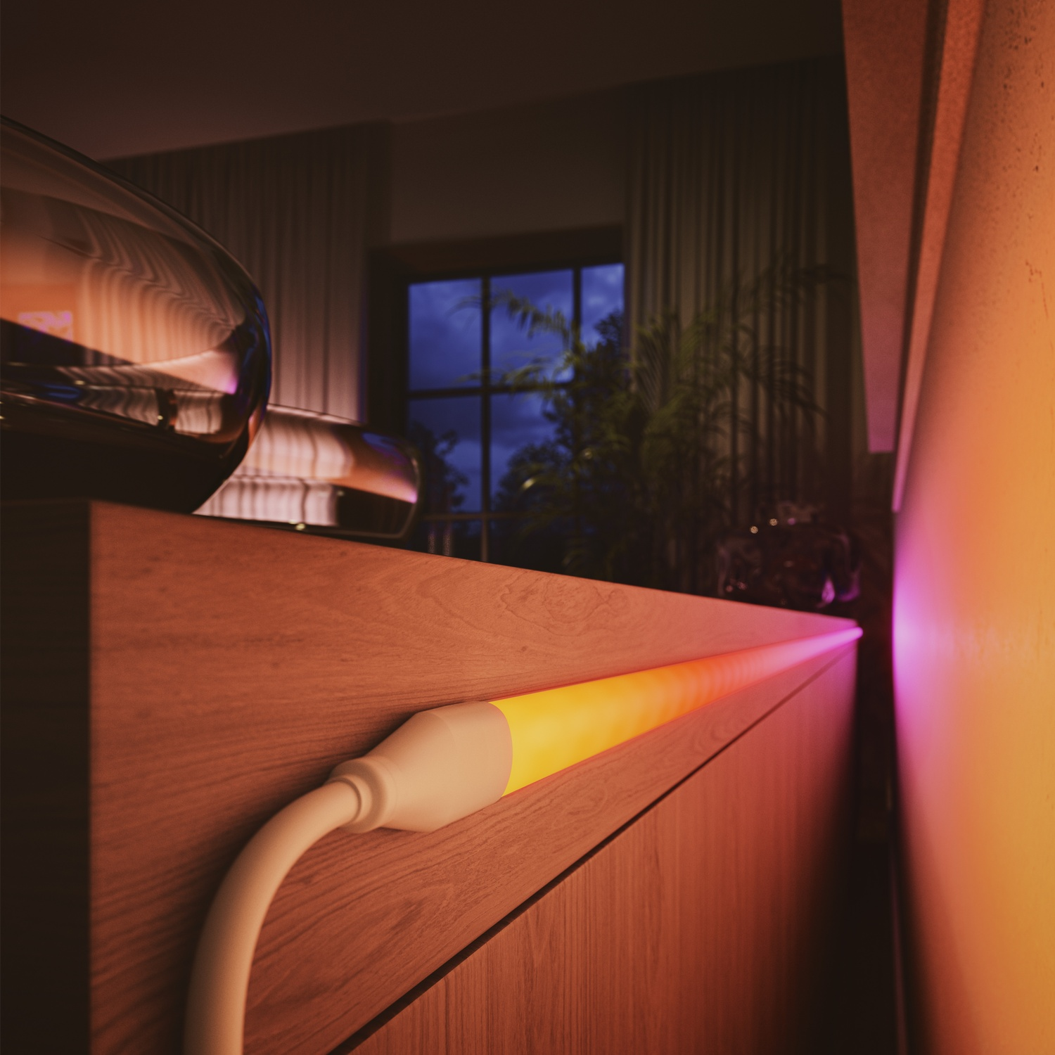 Una striscia luminosa incandescente su una superficie di legno. Un oggetto di vetro è sulla sinistra. Una finestra e delle piante sono visibili sullo sfondo.