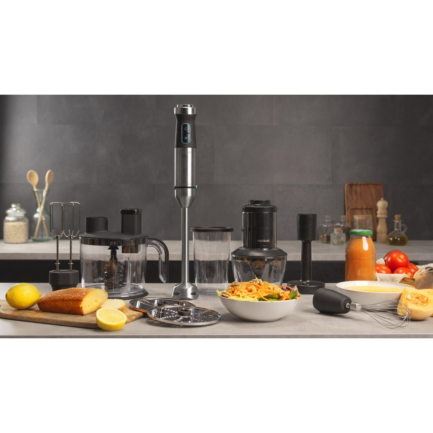 Una scena di cucina con vari accessori per robot da cucina, cibo e ingredienti su un piano di lavoro. Un frullatore è al centro.