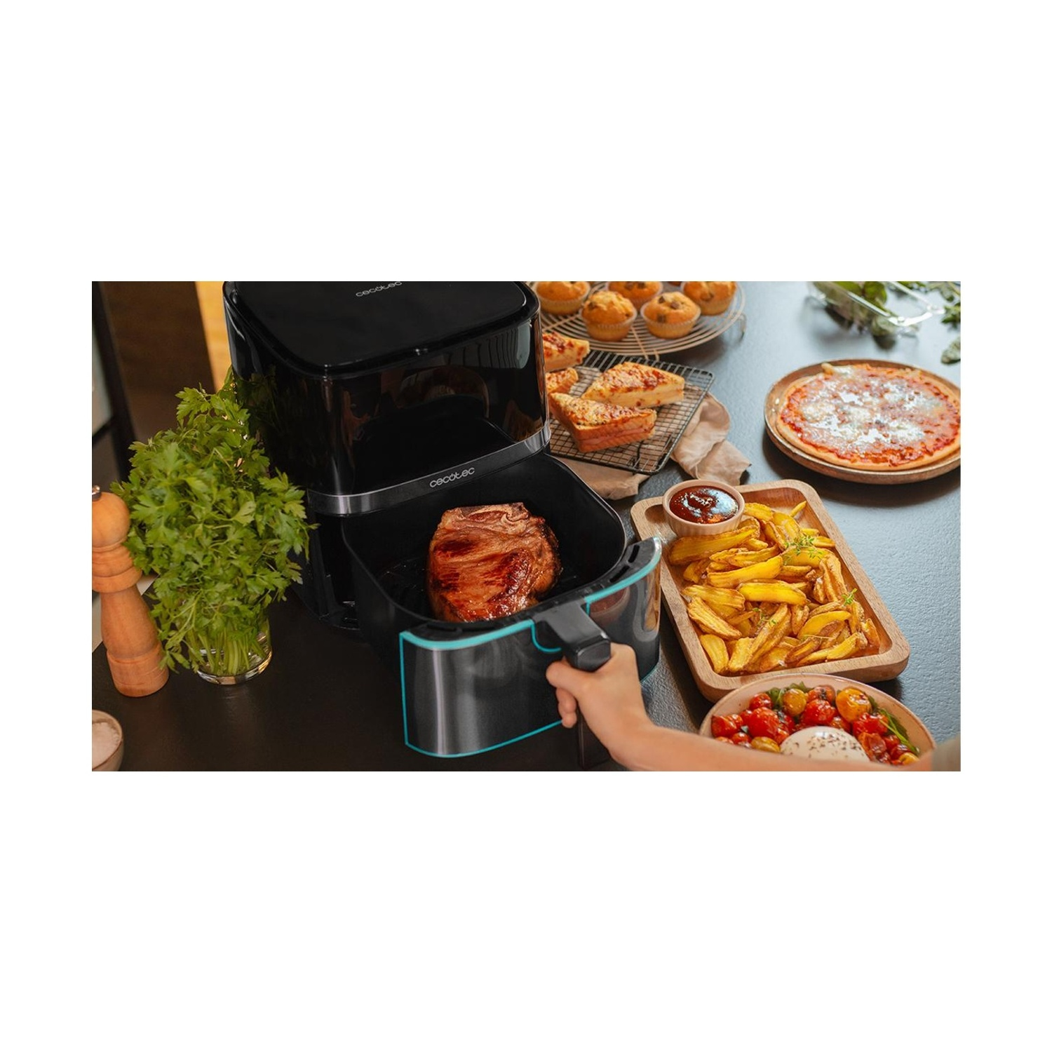 Una friggitrice ad aria con bistecca, circondata da cibo: pizza, patatine fritte, muffin e insalata. Una mano tiene il cestello.
