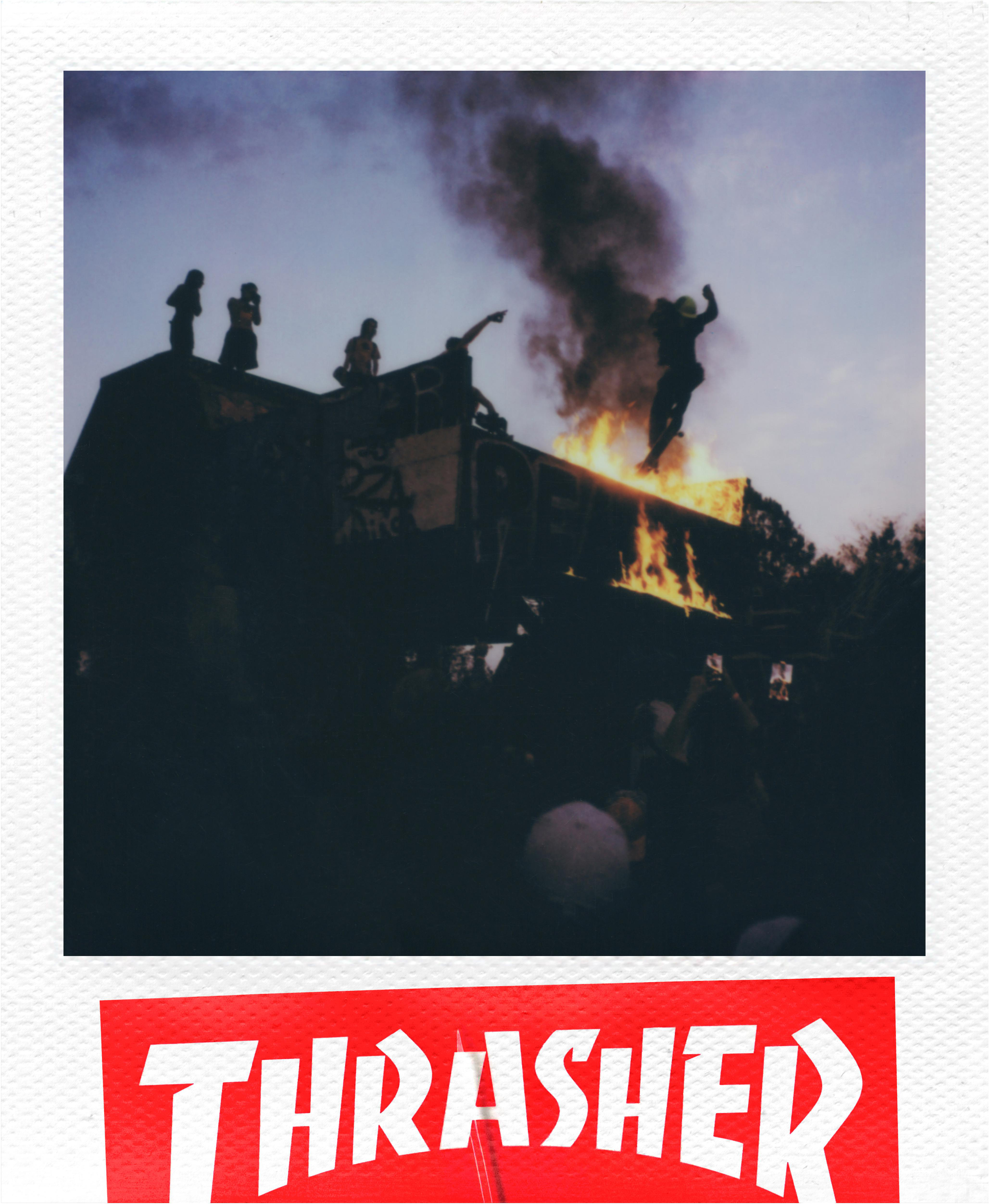 Menschen auf einer brennenden Struktur mit Flammen. Schwarzer Rauch steigt gegen den Himmel. 'Thrasher'-Logo unten.