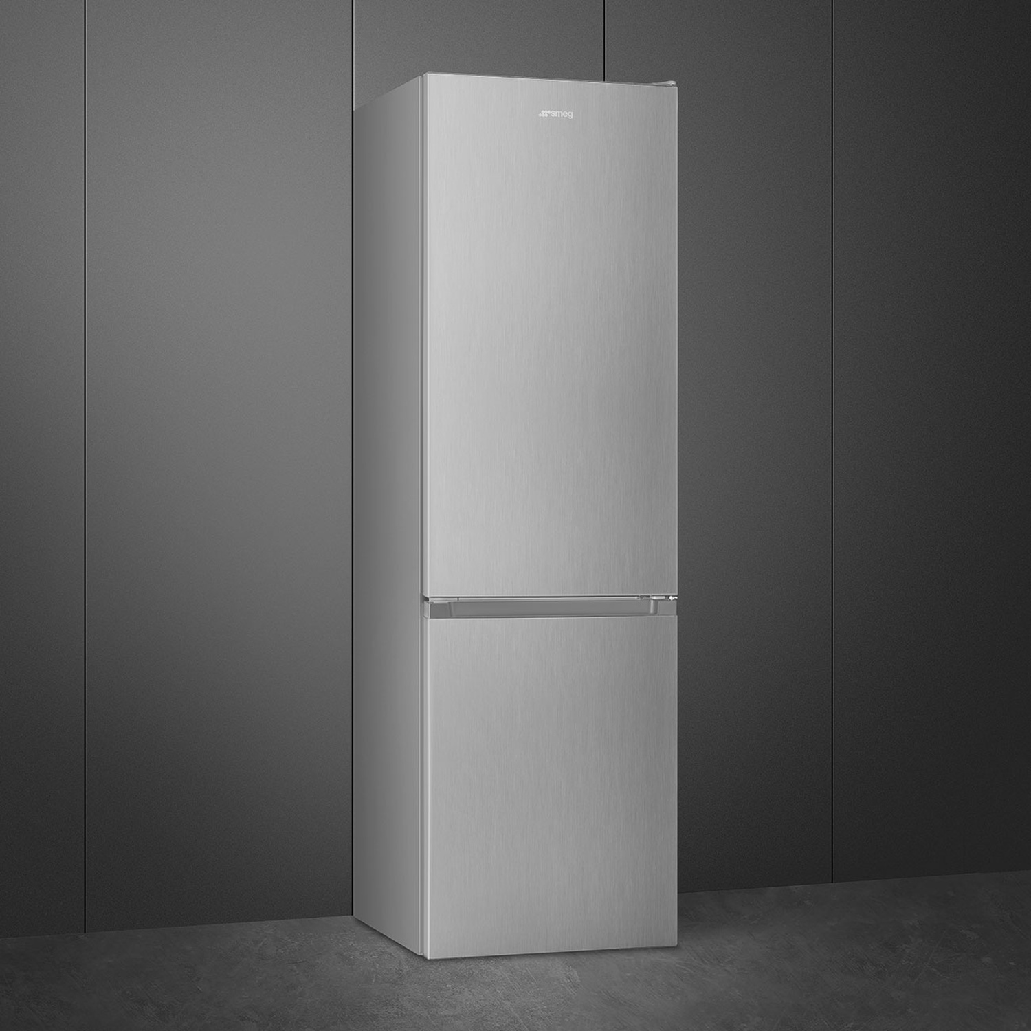 Un frigorifero Smeg alto e argentato si trova contro un muro grigio scuro. Il frigorifero ha due porte e una maniglia.