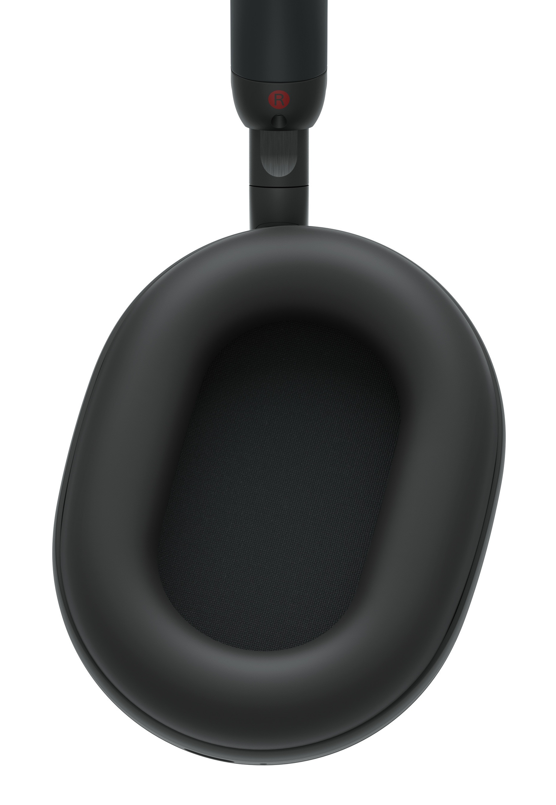 Zbliżenie czarnych słuchawek. Nausznica jest owalna, z materiałowym wnętrzem i wyściełaną obwódką. Tło jest białe.