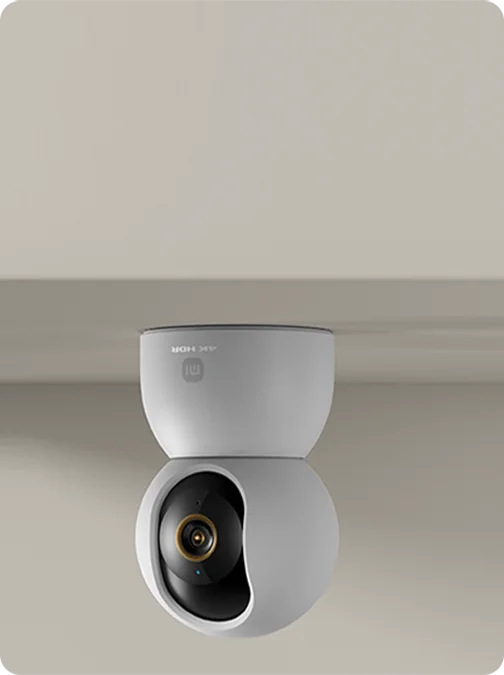 Biała kamera bezpieczeństwa z czarnym obiektywem na neutralnym tle. Kamera posiada logo i etykietę 4K HDR.