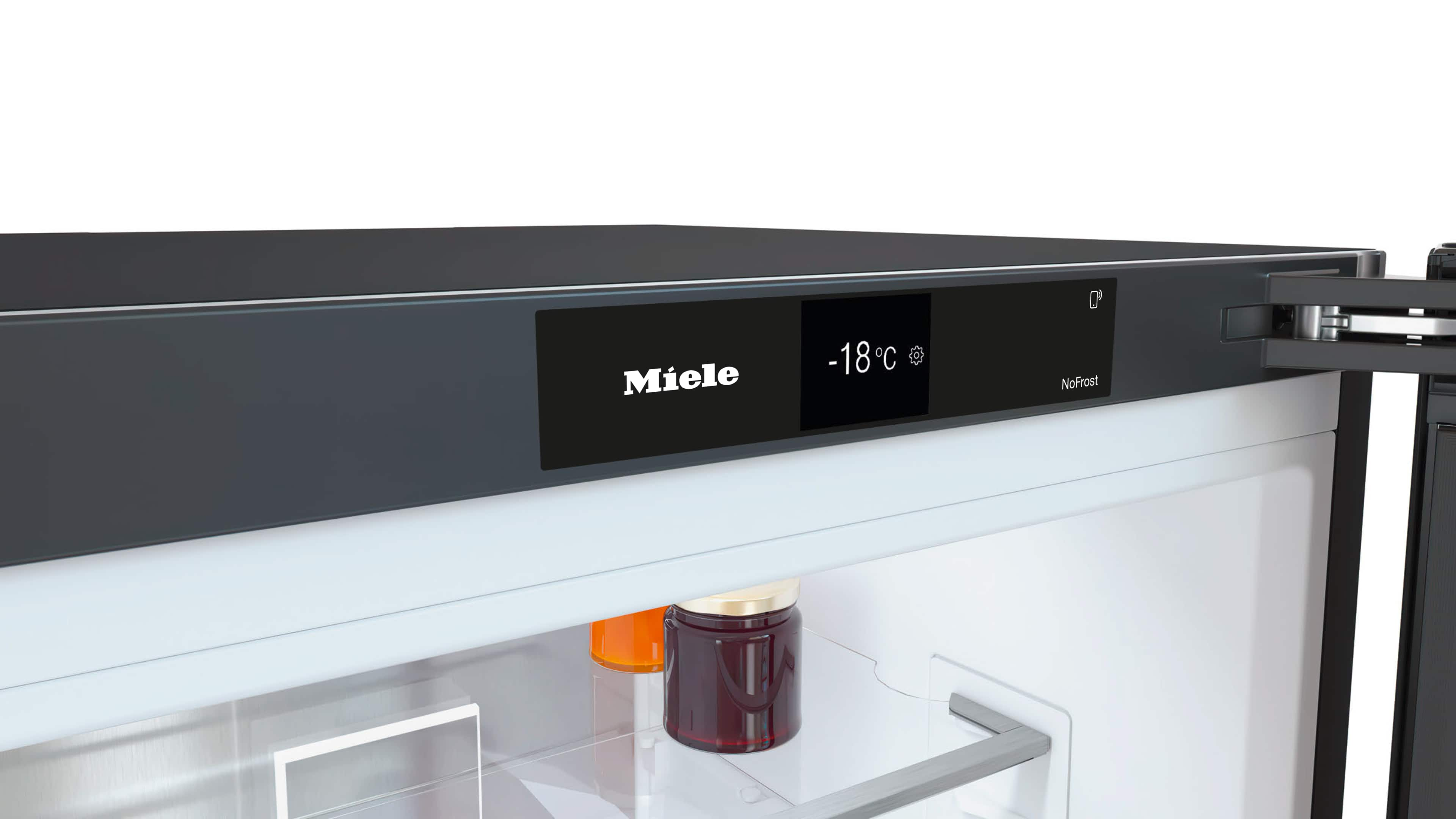 Ein Miele-Kühlschrank zeigt -18°C. Gläser mit Marmelade und Saft sind im Inneren sichtbar. Etikett NoFrost. Die Tür ist geöffnet.