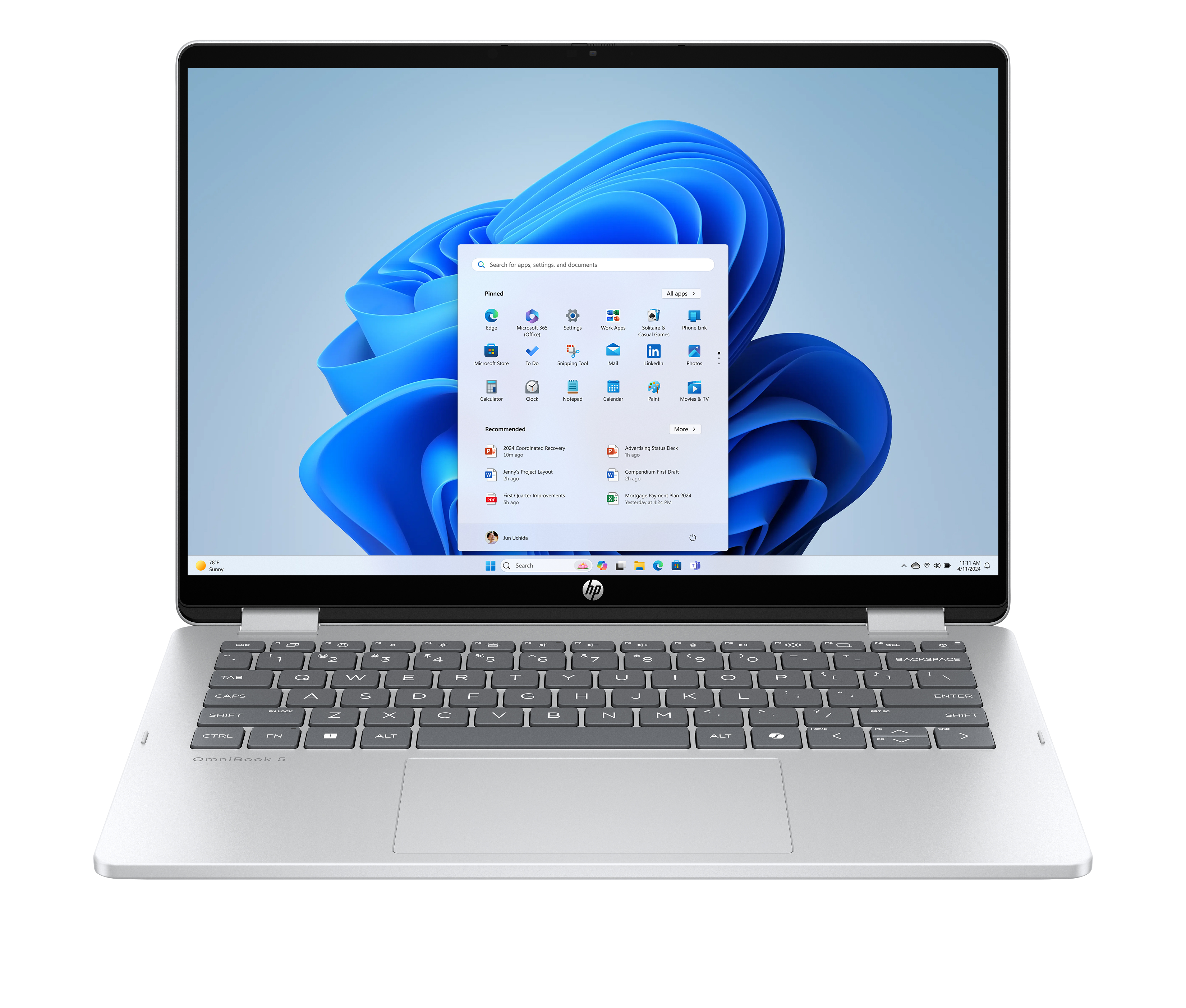 Laptop z pulpitem Windows 11, ikonami aplikacji i paskiem wyszukiwania. Klawiatura widoczna.