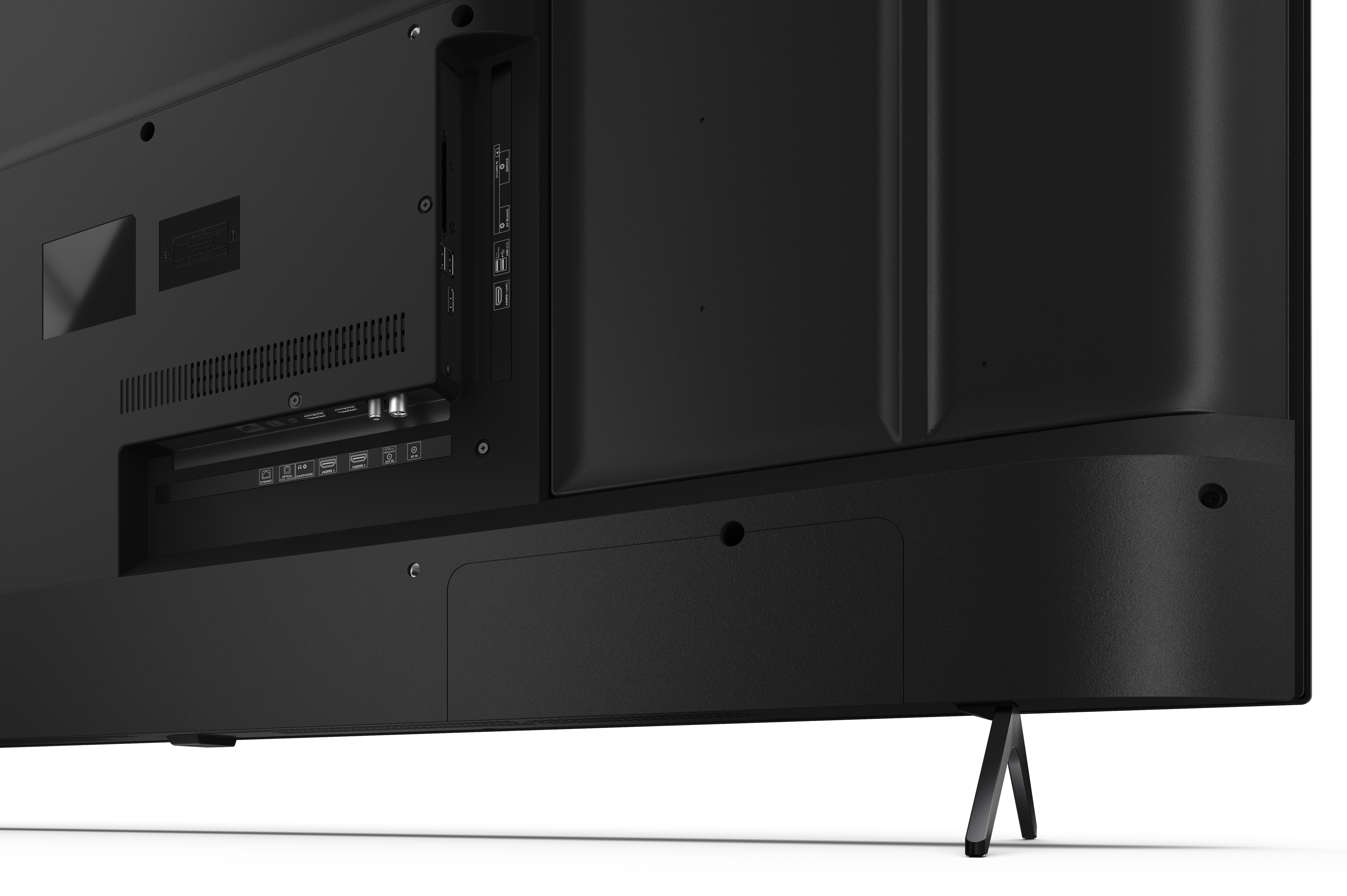 Zbliżenie na tył czarnego telewizora, pokazujące porty, złącza i stojak. Powierzchnia jest teksturowana.