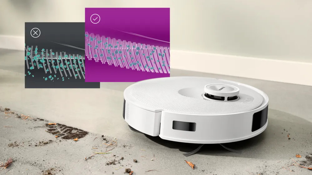 Biały robot sprzątający na betonowej podłodze. Dwa diagramy pokazują porównania szczotek czyszczących. Obecne są zanieczyszczenia i ślad stopy.