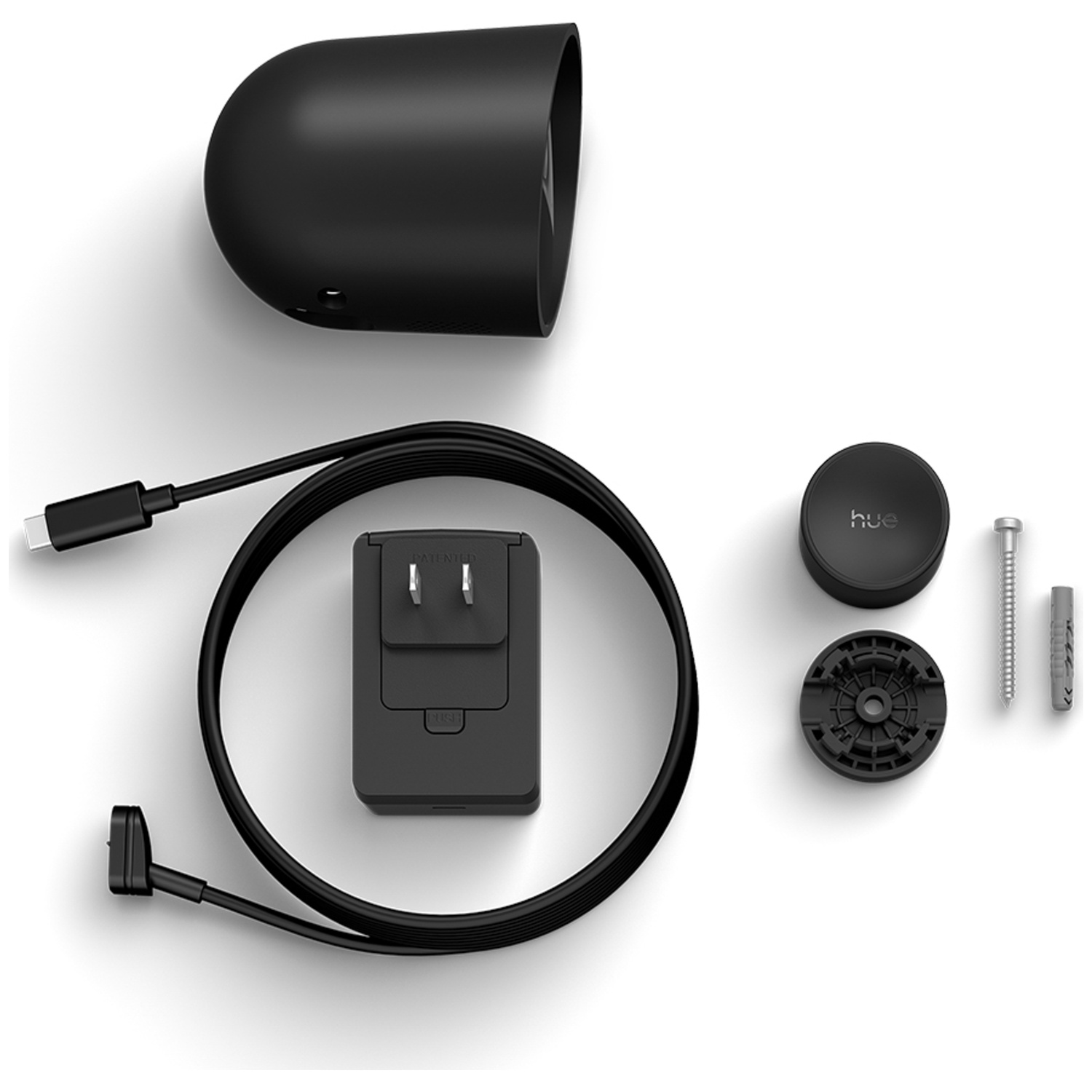 A black security camera kit on a white surface. Includes a camera housing, charger, cable, mounting hardware, and a base.
