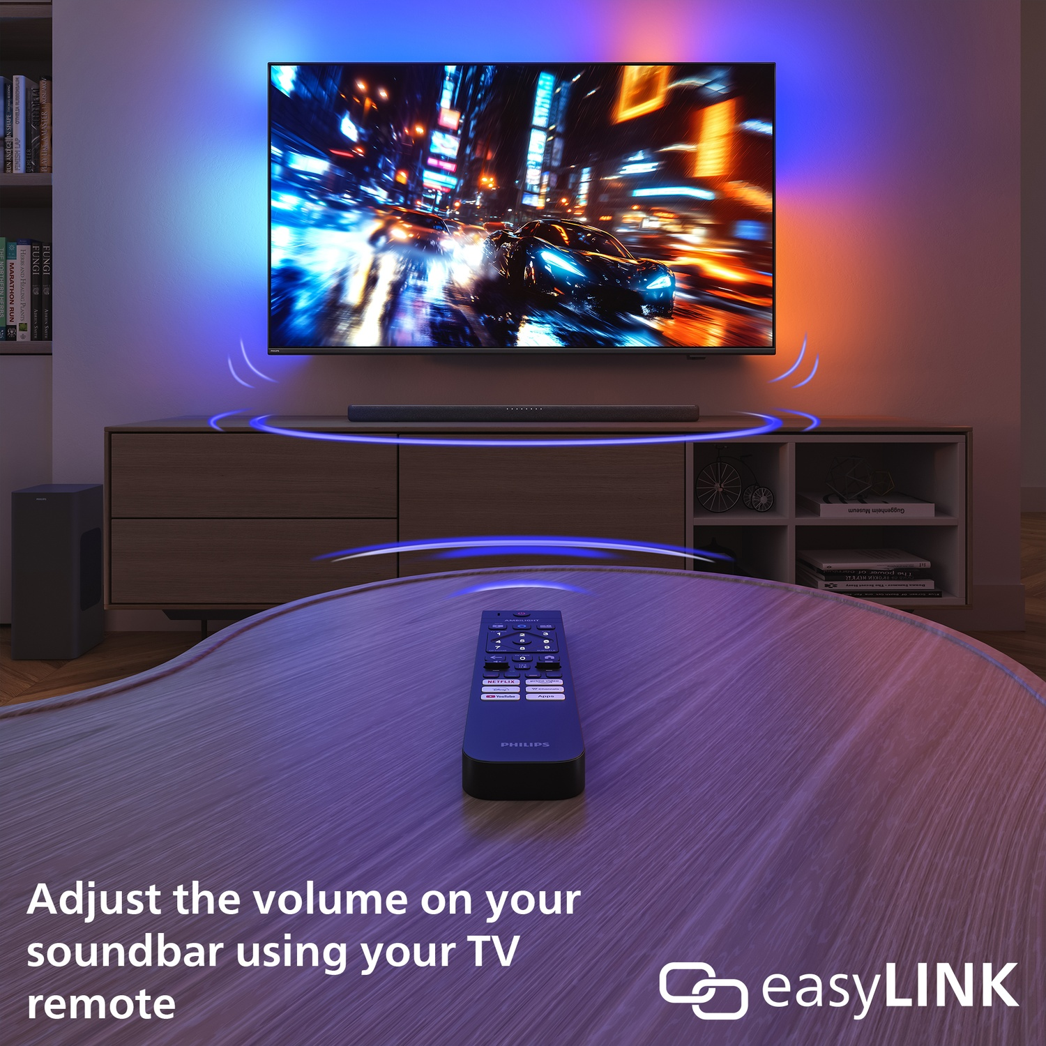 Een tv met een stadsbeeld, een soundbar, een afstandsbediening en een tafel. De afstandsbediening ligt op de tafel. De afbeelding promoot easyLink.
