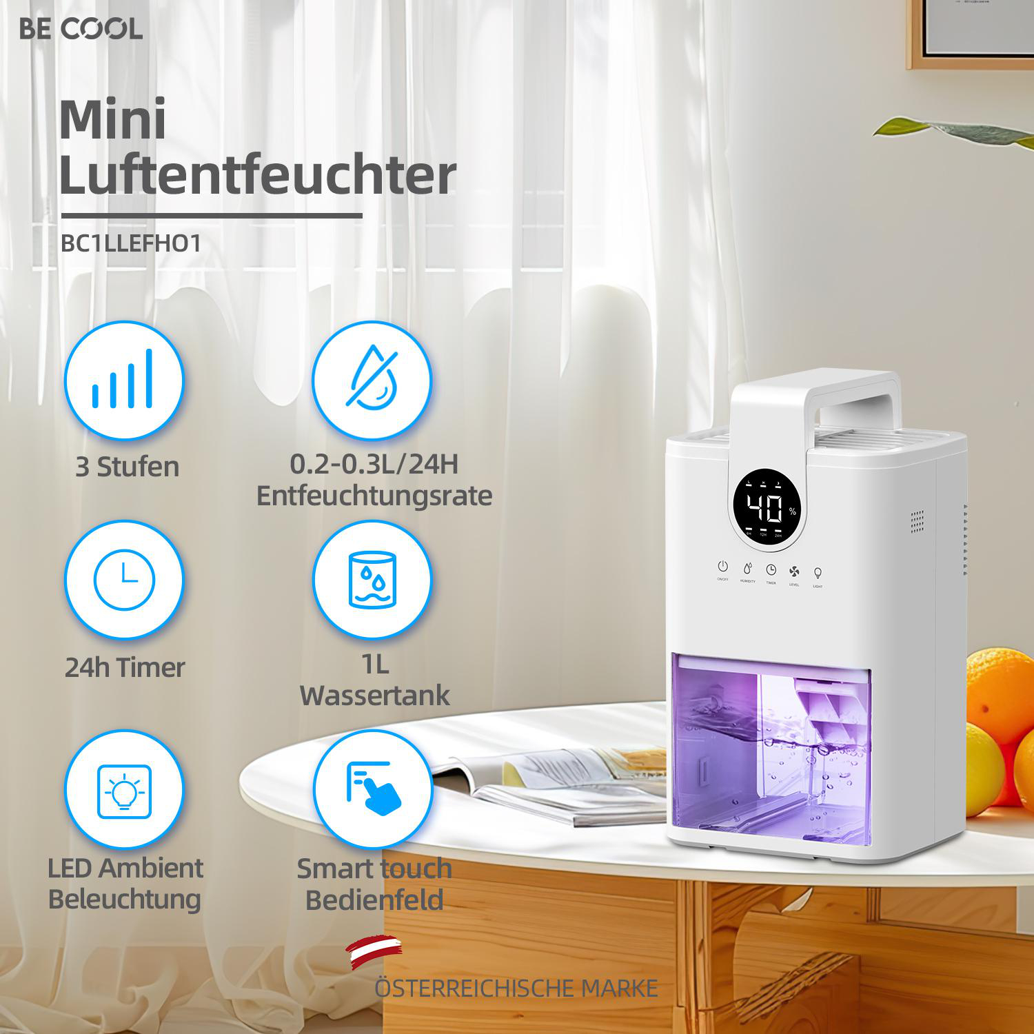 Ein weißer Mini-Luftentfeuchter mit Digitalanzeige, Wassertank und Bedienelementen. Symbole zeigen Funktionen. Orangen und Zitronen rechts.