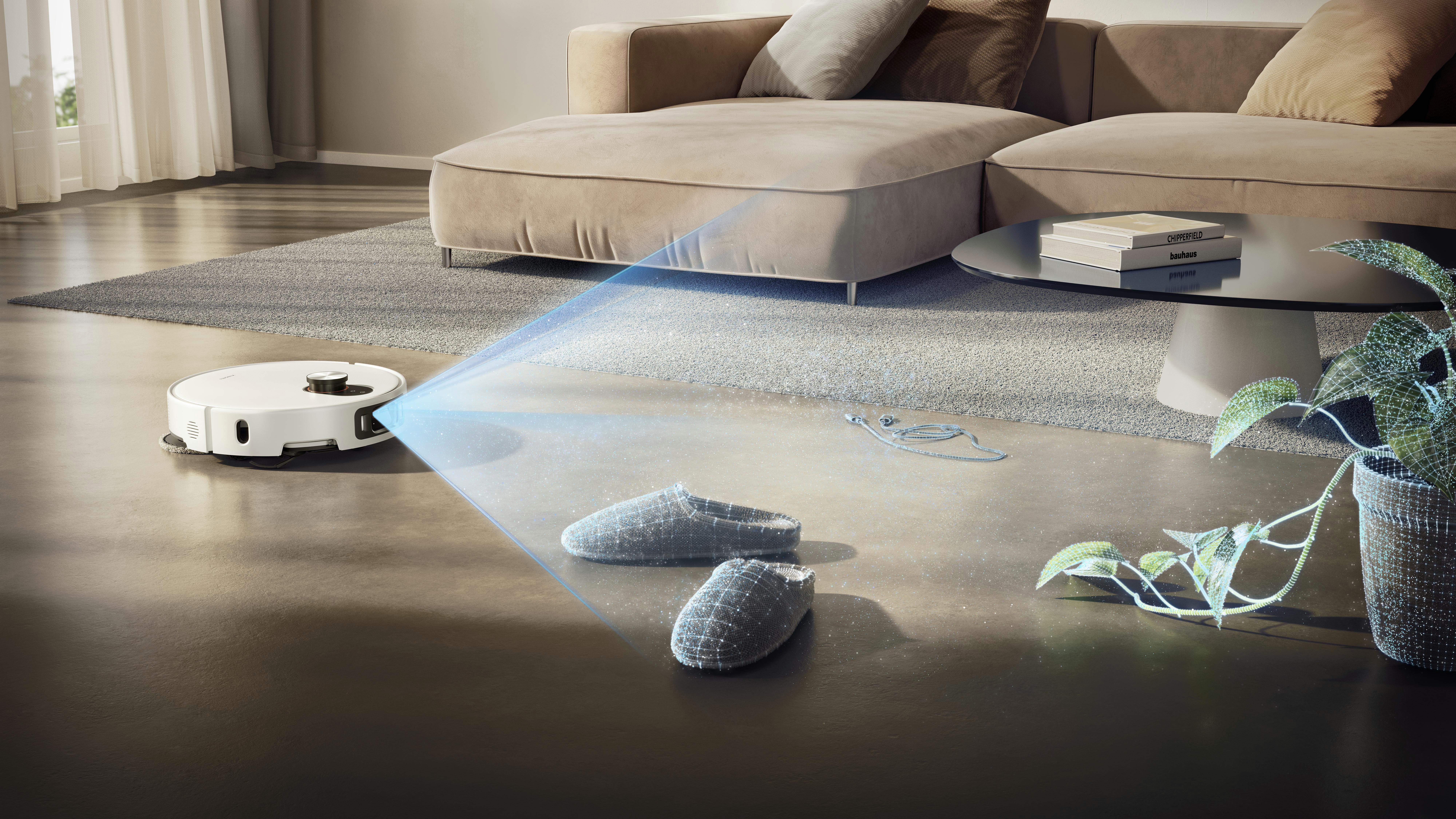 Ein Roboterstaubsauger reinigt ein Wohnzimmer. Es gibt ein Sofa, einen Couchtisch, Hausschuhe und eine Pflanze.
