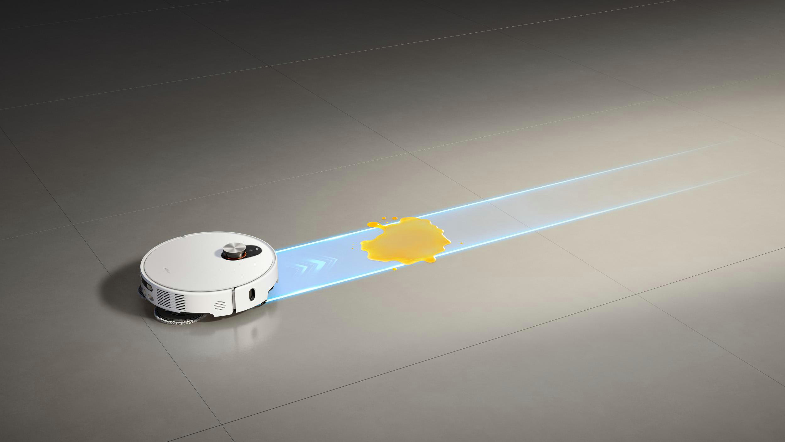 Ein weißer Roboter-Staubsauger reinigt einen Boden mit einer gelben Verschüttung. Blaue Lichtspuren zeigen den Reinigungspfad.