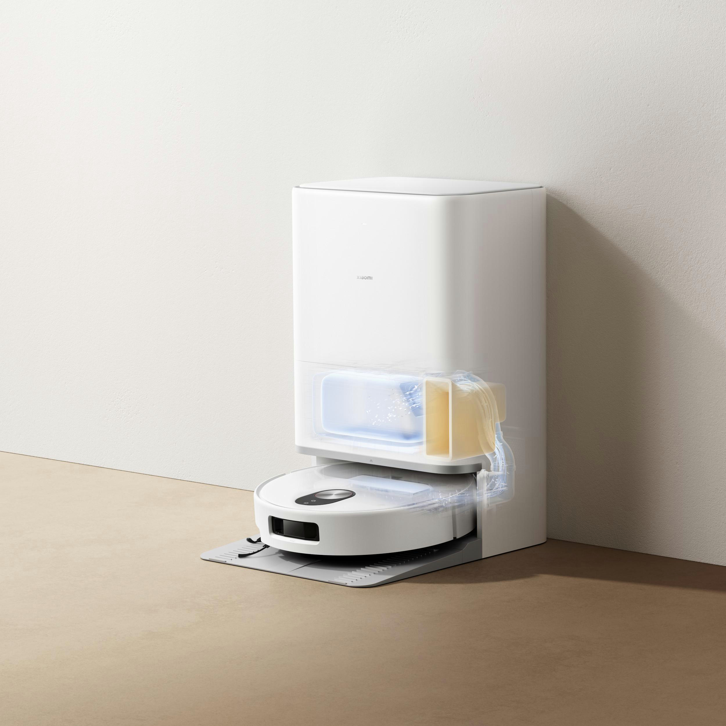 Ein weißer Roboter-Staubsauger mit Ladestation. Die Station hat einen transparenten Wassertank.