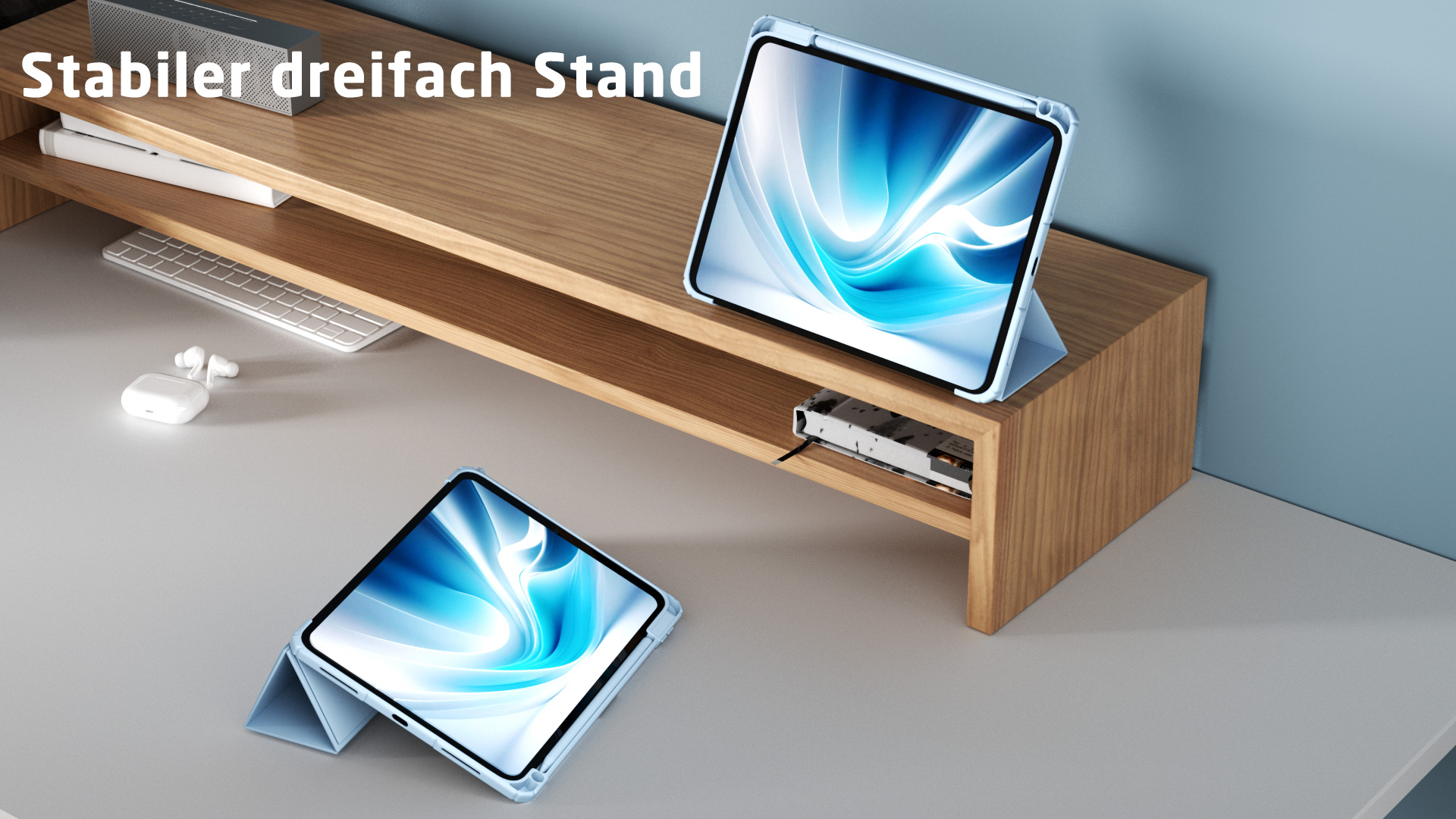 Tisch mit drei Tablets, eines auf einem Ständer, andere flach. Tastatur, Ohrhörer und Lautsprecher auf dem Tisch.