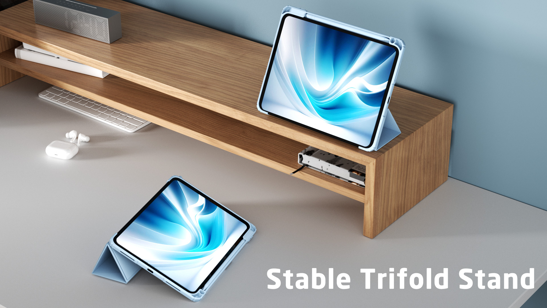 Zwei Tablets in Ständern, Schreibtisch mit Tastatur, AirPods und Lautsprecher. Holzständer im Hintergrund, blaue Wand.
