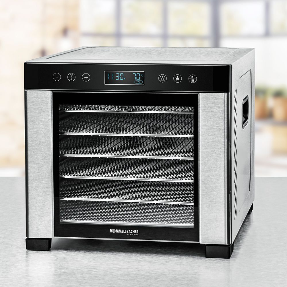 Un essiccatore per alimenti in acciaio inossidabile. Ha un display digitale con ora e temperatura, con più vassoi visibili attraverso la porta di vetro.